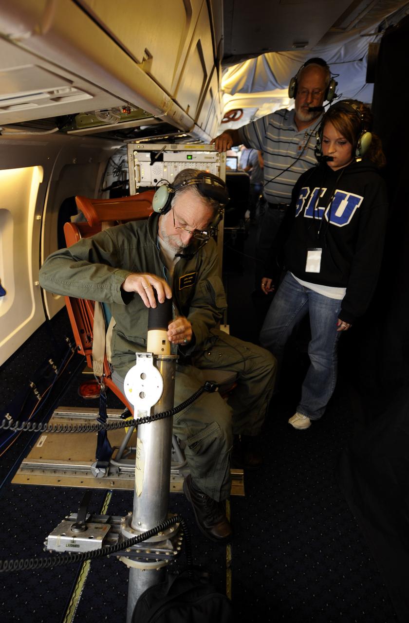 Errol Korn, seated left, deploys a dropsonde experiment over the Gulf of Mexico during a flight aboard the NASA DC-8 as  Janel Thomas, a University of Maryland Baltimore County (UMBC) graduate student, and Bob Pasken, look on , Tuesday, Aug. 17, 2010.  The Genesis and Rapid Intensification Processes (GRIP) experiment is a NASA Earth science field experiment in 2010 that is being conducted to better understand how tropical storms form and develop into major hurricanes. Photo Credit: (NASA/Paul E. Alers)