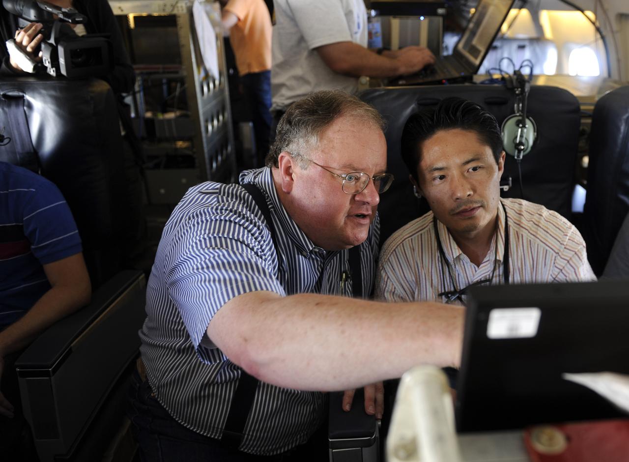 Michael Kavaya, of the NASA Langley Research Center, a Principal Investigator for the DAWN experiment, looks over data with Jeffrey Beyon during a flight of the NASA DC-8, Tuesday, Aug. 17, 2010, in the Gulf of Mexico. The DAWN experiment, also known as the Doppler Aerosol Wind Lidar, is one of many experiments supporting the Genesis and Rapid Intensification Processes (GRIP) experiment, a NASA Earth science field experiment in 2010 that is being conducted to better understand how tropical storms form and develop into major hurricanes. Photo Credit: (NASA/Paul E. Alers)