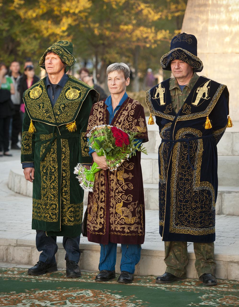 Russian Cosmonaut Gennady Padalka, left, NASA Astronaut Peggy Whitson, center, and Russian Cosmonaut Valery Korzun are seen in traditional Kazakh dress during a ceremony where they were recognized for their achievements in space flight on Thursday, Sept. 23, 2010 in Jhezkazgan, Kazakhstan. Padalka, Whitson, and Korzun were in Jhezkazgan in preparation for the Expedition 24 Soyuz TMA-18 spacecraft landing. Photo Credit: (NASA/Bill Ingalls)