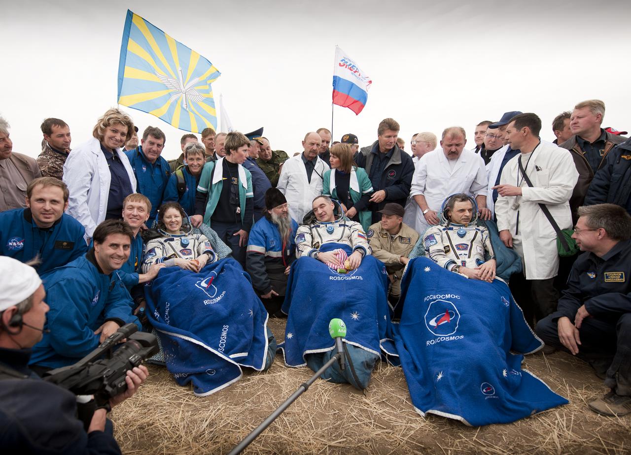 Expedition 24 Flight Engineers Tracy Caldwell Dyson, left, Commander Alexander Skvortsov, center and Mikhail Kornienko sit in chairs outside the Soyuz Capsule just minutes after they landed near the town of Arkalyk, Kazakhstan on Saturday, Sept. 25, 2010. Russian Cosmonauts Skvortsov and Kornienko and NASA Astronaut Caldwell Dyson, are returning from six months onboard the International Space Station where they served as members of the Expedition 23 and 24 crews. Photo Credit: (NASA/Bill Ingalls)