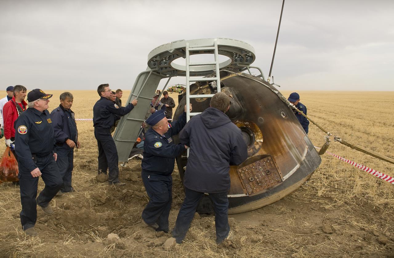Russian search and rescue personnel and engineers prepare to extract the crew from the Soyuz TMA-18 moments after it landed with Expedition 24 Commander Alexander Skvortsov and Flight Engineers Tracy Caldwell Dyson and Mikhail Kornienko near the town of Arkalyk, Kazakhstan on Saturday, Sept. 25, 2010. Russian Cosmonauts Skvortsov and Kornienko and NASA Astronaut Caldwell Dyson, are returning from six months onboard the International Space Station where they served as members of the Expedition 23 and 24 crews. Photo Credit: (NASA/Bill Ingalls)