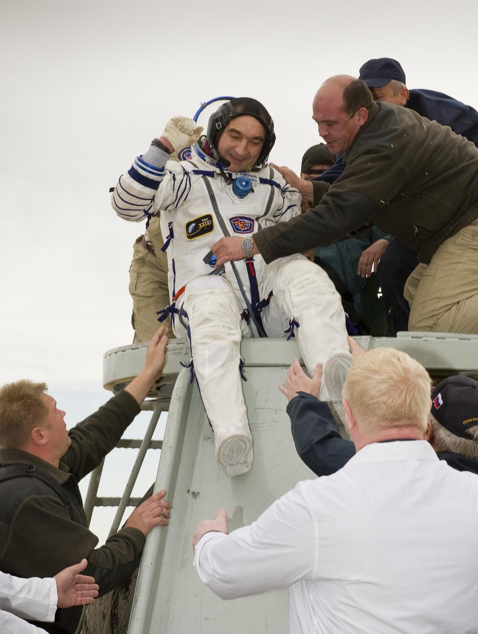 Expedition 24 Commander Alexander Skvortsov celebrates as he is helped out of the Soyuz TMA-18 spacecraft shortly after landing with fellow crew members Tracy Caldwell Dyson and Mikhail Kornienko near the town of Arkalyk, Kazakhstan on Saturday, Sept. 25, 2010. Russian Cosmonauts Skvortsov and Kornienko and NASA Astronaut Caldwell Dyson, are returning from six months onboard the International Space Station where they served as members of the Expedition 23 and 24 crews. Photo Credit: (NASA/Bill Ingalls)