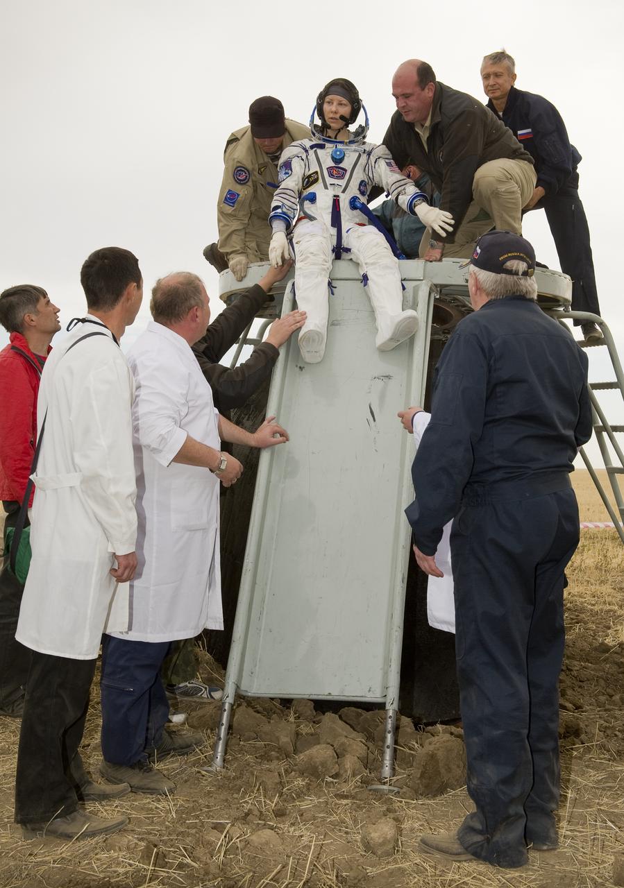 Expedition 24 Flight Engineer Tracy Caldwell Dyson is helped out of the Soyuz TMA-18 spacecraft shortly after landing with fellow crew members Commander Alexander Skvortsov and Mikhail Kornienko near the town of Arkalyk, Kazakhstan on Saturday, Sept. 25, 2010. Russian Cosmonauts Skvortsov and Kornienko and NASA Astronaut Caldwell Dyson, are returning from six months onboard the International Space Station where they served as members of the Expedition 23 and 24 crews. Photo Credit: (NASA/Bill Ingalls)