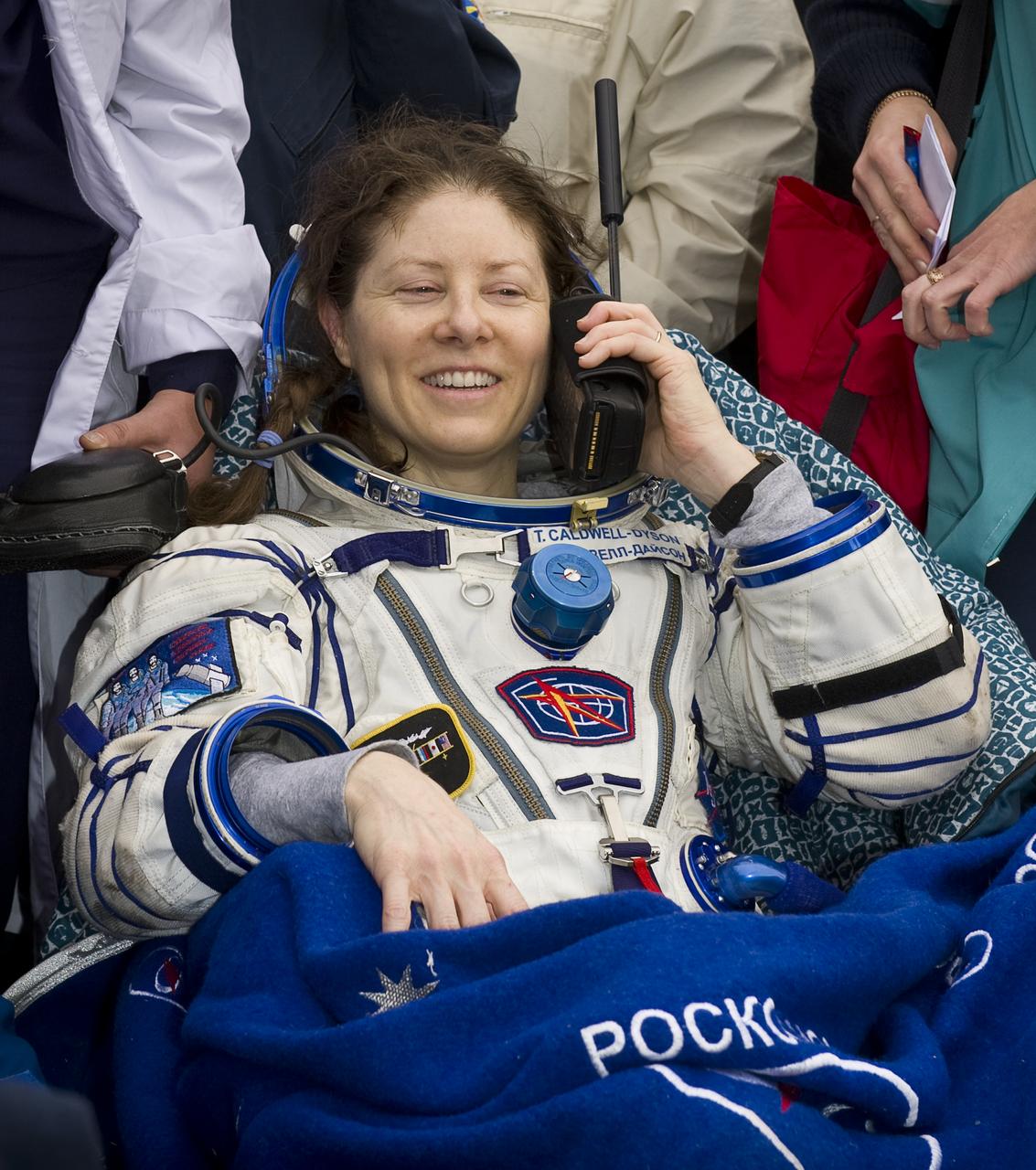Expedition 24 Flight Engineer Tracy Caldwell Dyson talks to her husband on a satellite phone shortly after landing in the Soyuz TMA-18 spacecraft with fellow crew members Commander Alexander Skvortsov and Mikhail Kornienko near the town of Arkalyk, Kazakhstan on Saturday, Sept. 25, 2010. Russian Cosmonauts Skvortsov and Kornienko and NASA Astronaut Caldwell Dyson, are returning from six months onboard the International Space Station where they served as members of the Expedition 23 and 24 crews. Photo Credit: (NASA/Bill Ingalls)