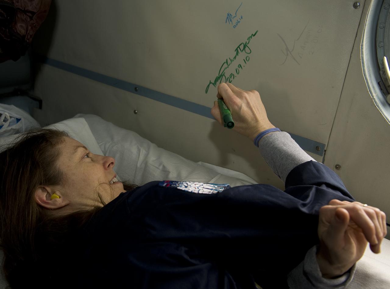 Expedition 24 Flight Engineer Tracy Caldwell Dyson signs the inside of the Russian helicopter that took her from the Soyuz TMA-18 spacecraft landing site near Arkalyk, Kazakhstan to Karaganda, Kazakhstan on Saturday, Sept. 25, 2010. Russian Cosmonauts Skvortsov and Kornienko and NASA Astronaut Caldwell Dyson returned from six months onboard the International Space Station where they served as members of the Expedition 23 and 24 crews. Photo Credit: (NASA/Bill Ingalls)