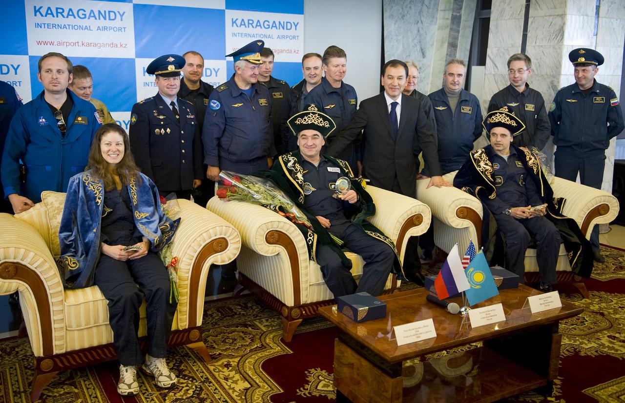 Expedition 24 Flight Engineer Tracy Caldwell Dyson, left, Expedition 24 Commander Alexander Skvortsov, center, and Expedition 24 Flight Engineer Mikhail Kornienko answer reporters questions in traditional Kazakh dress during a post flight ceremony and press conference at the Karaganda airport in Kazakhstan on Saturday, Sept. 25, 2010. The Soyuz TMA-18 spacecraft, carrying Expedition 24 Commander Alexander Skvortsov and Flight Engineers Tracy Caldwell Dyson and Mikhail Kornienko, landed, near the town of Arkalyk, Kazakhstan on Saturday, Sept. 25, 2010. Russian Cosmonauts Skvortsov and Kornienko and NASA Astronaut Caldwell Dyson, are returning from six months onboard the International Space Station where they served as members of the Expedition 23 and 24 crews. Photo Credit: (NASA/Bill Ingalls)