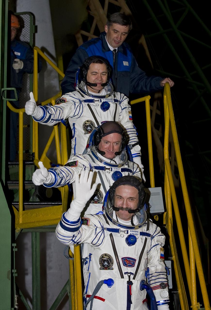 Expedition 25 Soyuz Commander Alexander Kaleri of Russia, bottom, NASA Flight Engineer Scott Kelly of the U.S., center, and Russian Flight Engineer Oleg Skripochka wave farewell from the bottom of the soyuz rocket at the Baikonur Cosmodrome in Baikonur, Kazakhstan, Friday, Oct. 8, 2010.  Kaleri, Kelly and Skripochka launched in their Soyuz TMA-01M rocket later that morning at 5:10 a.m. Kazakhstan time. (Photo Credit: NASA/Carla Cioffi)