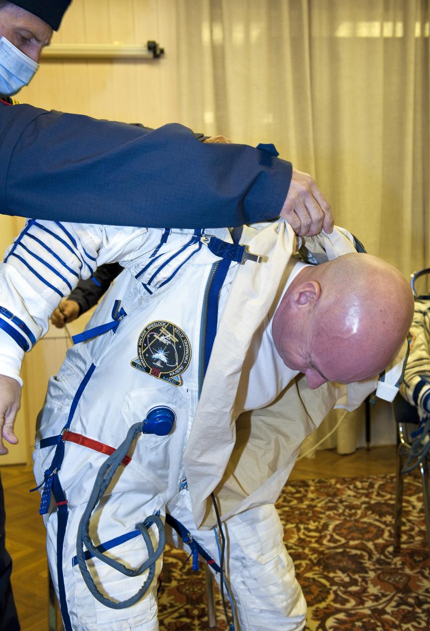 Expedition 25 NASA Flight Engineer Scott Kelly of the U.S. has his Russian Sokol suit prepared for launch by a technician at the Baikonur Cosmodrome in Kazakhstan, Friday, Oct. 8, 2010.  Kelly and fellow Expedition 25 crew members Soyuz Commander Alexander Kaleri and Flight Engineer Oleg Skripochka launched in their Soyuz TMA-01M at 5:10 a.m. Friday morning. (Photo Credit: NASA/Carla Cioffi)