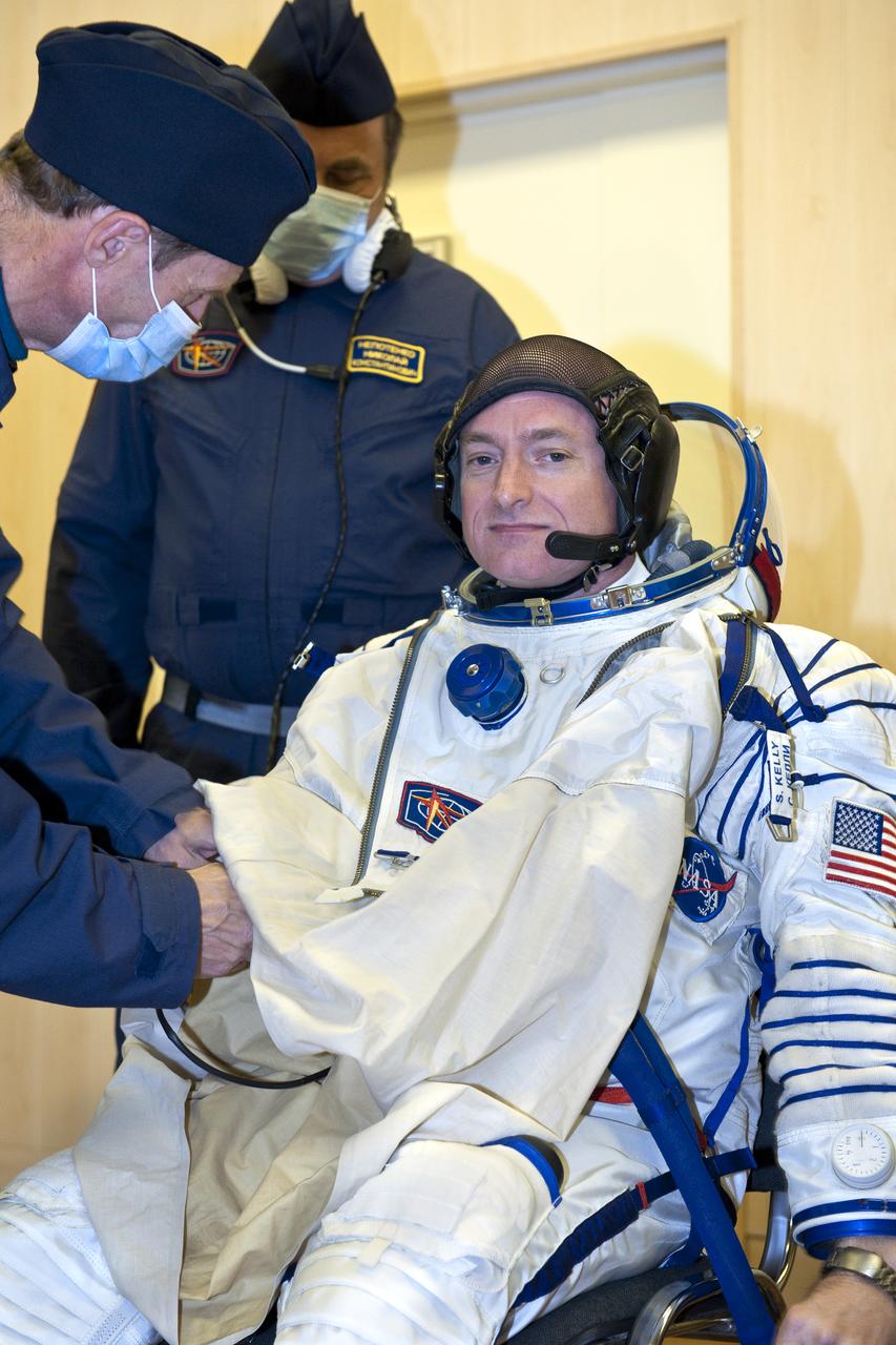Expedition 25 NASA Flight Engineer Scott Kelly of the U.S. has his Russian Sokol suit prepared for launch by a technician at the Baikonur Cosmodrome in Baikonur, Kazakhstan, Friday, Oct. 8, 2010.  Kelly and fellow Expedition 25 crew members Soyuz Commander Alexander Kaleri and Flight Engineer Oleg Skripochka launched in their Soyuz TMA-01M at 5:10 a.m. Friday morning. (Photo Credit: NASA/Carla Cioffi)