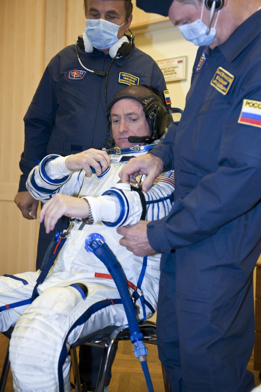 Expedition 25 NASA Flight Engineer Scott Kelly of the U.S. has his Russian Sokol suit prepared for launch by a technician at the Baikonur Cosmodrome in Baikonur, Kazakhstan, Friday, Oct. 8, 2010.  Kelly and fellow Expedition 25 crew members Soyuz Commander Alexander Kaleri and Flight Engineer Oleg Skripochka launched in their Soyuz TMA-01M at 5:10 a.m. Friday morning. (Photo Credit: NASA/Carla Cioffi)