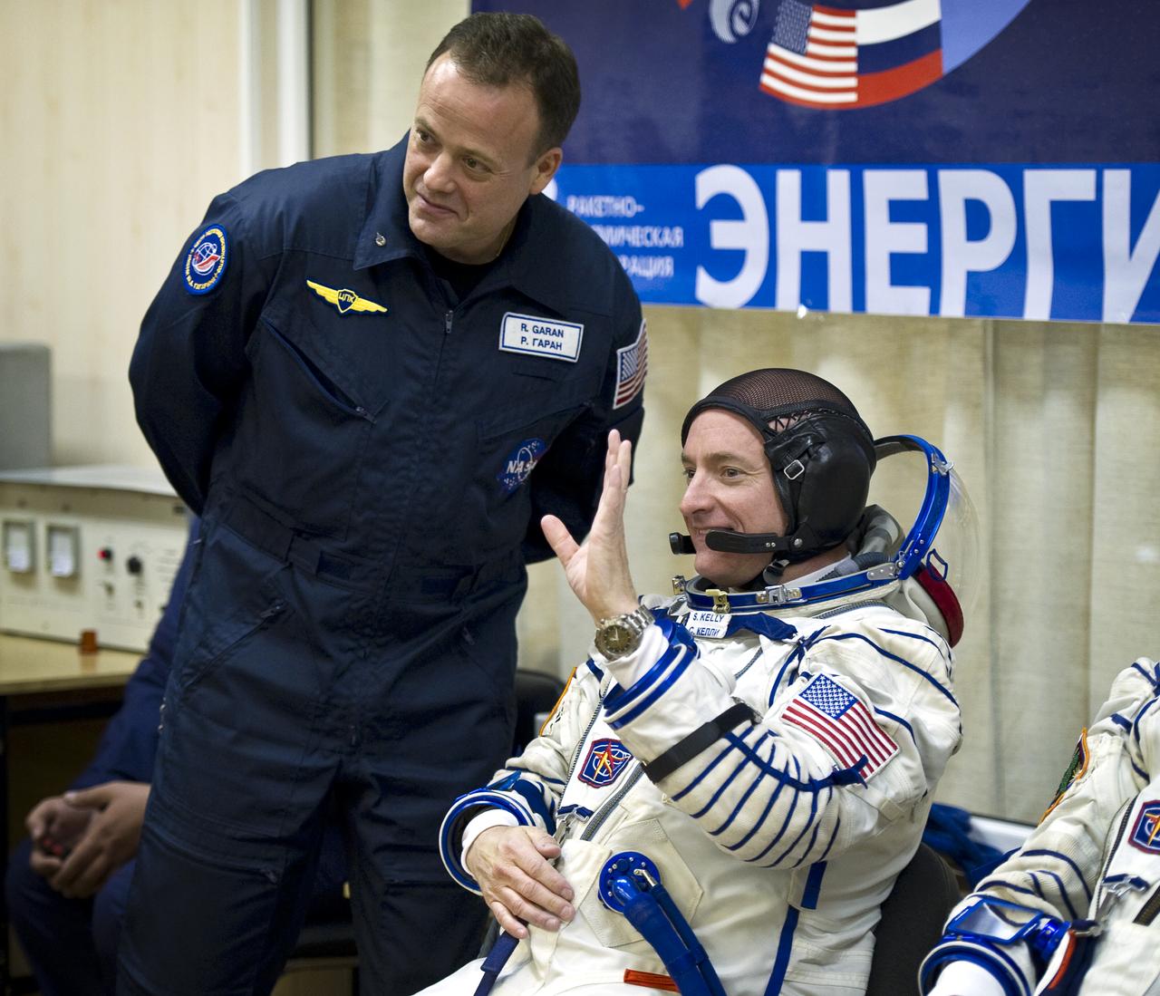Expedition 25 NASA Flight Engineer Scott Kelly waves to friends and family as he awaits to have his Russian Sokol Suit pressure checked at the Baikonur Cosmodrome in Kazakhstan on Friday, Oct. 8, 2010.  Backup crew member Ron Garan, left, looks on.  Photo Credit: (NASA/Carla Cioffi)