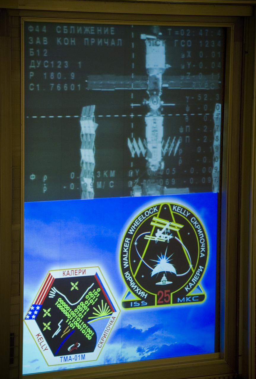The Soyuz TMA-01M nears its docking with the International Space Station as seen in the video monitor at Russian Mission Control Center in Korolev, Russia on Sunday, Oct. 10, 2010.  The TMA-01M delivered the crew of Expedition 25 Soyuz Commander Alexander Kaleri, Flight Engineer Scott Kelly and Flight Engineer Oleg Skripochka to the ISS.  Photo Credit: (NASA/Carla Cioffi)
