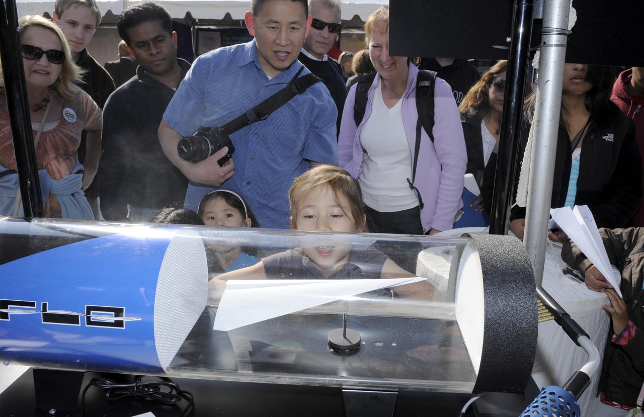 A young girl watches as her paper airplane is flown in a small wind tunnel during the USA Science and Engineering Festival, Saturday, Oct. 23, 2010, at Freedom Plaza in Washington. NASA, joined with more than 500 science organizations this weekend to inspire the next generation of scientists and engineers during the first national science and engineering festival held in the nation's capital. Photo Credit: (NASA/Paul E. Alers)