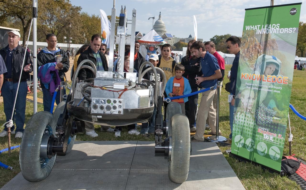 Visitors to the USA Science and Engineering Festival look on at one of the many exhibits, Saturday, Oct. 23, 2010, on the National Mall in Washington. NASA, joined with more than 500 science organizations this weekend to inspire the next generation of scientists and engineers during the first national science and engineering festival held in the nation's capital. Photo Credit: (NASA/Paul E. Alers)