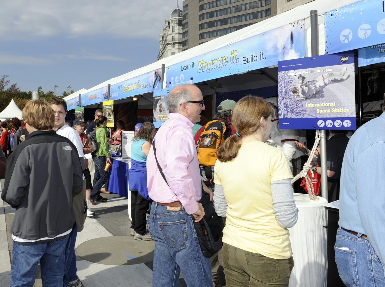 Visitors to the USA Science and Engineering Festival look over the many exhibits, Saturday, Oct. 23, 2010, at Freedom Plaza in Washington. NASA, joined with more than 500 science organizations this weekend to inspire the next generation of scientists and engineers during the first national science and engineering festival held in the nation's capital. Photo Credit: (NASA/Paul E. Alers)