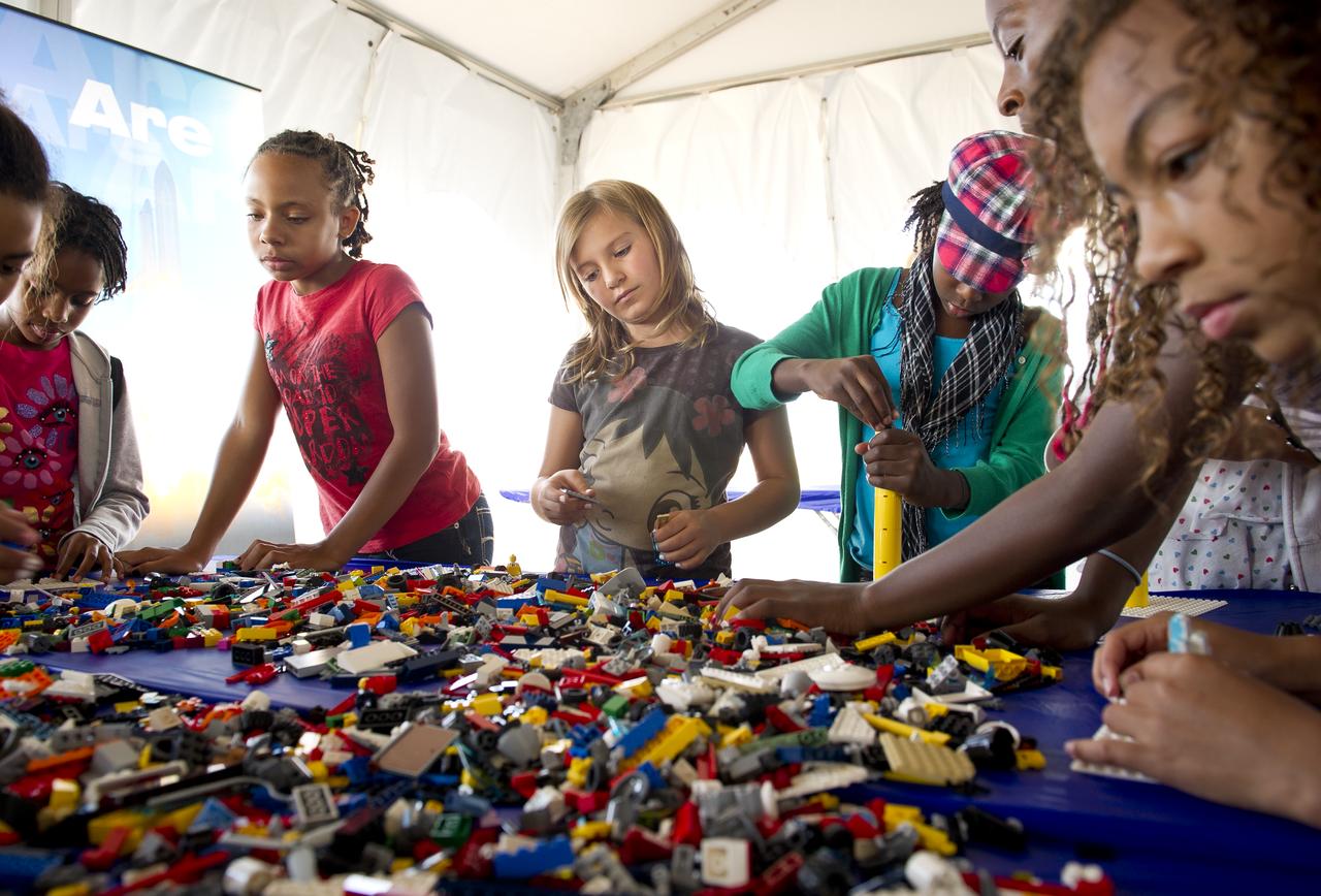 NASA Officials, LEGO Group management, students, teachers and parents create their vision of the future in space with LEGO bricks and elements as part of a “Build the Future” activity inside a tent that was set up on the launch viewing area at NASA's Kennedy Space Center in Cape Canaveral, Fla. on Monday, Nov. 1, 2010.  NASA and The LEGO Group signed a Space Act Agreement to spark children's interest in science, technology, engineering and math (STEM). Photo Credit: (NASA/Bill Ingalls)