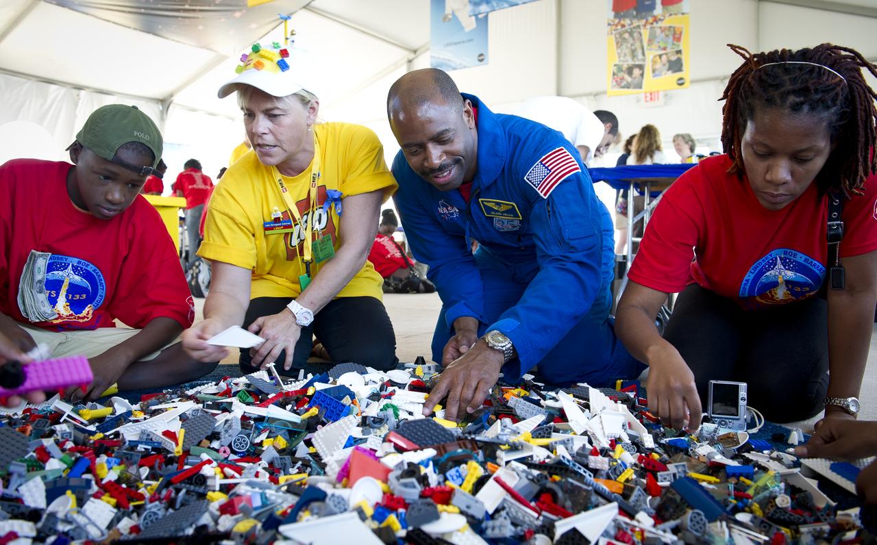 Associate Administrator for Education and Astronaut Leland Melvin, 3rd from left, talks with school children during the “Build the Future” activity where students created their vision of the future in space with LEGO bricks and elements inside a tent that was set up on the launch viewing area at NASA's Kennedy Space Center in Cape Canaveral, Fla. on Monday, Nov. 1, 2010.  NASA and The LEGO Group signed a Space Act Agreement to spark children's interest in science, technology, engineering and math (STEM). Photo Credit: (NASA/Bill Ingalls)
