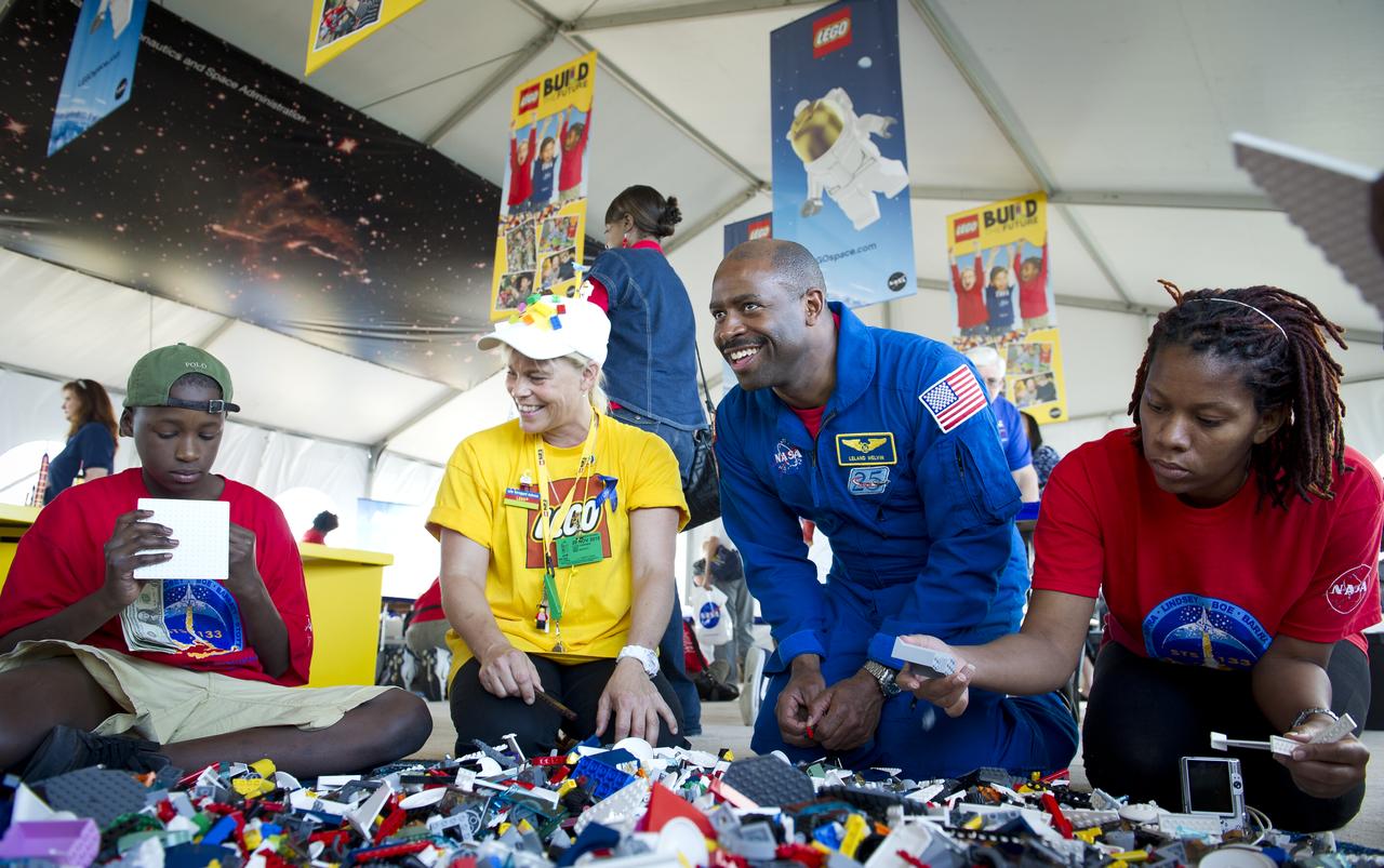 Associate Administrator for Education and Astronaut Leland Melvin, 3rd from left, talks with school children during the “Build the Future” activity where students created their vision of the future in space with LEGO bricks and elements inside a tent that was set up on the launch viewing area at NASA's Kennedy Space Center in Cape Canaveral, Fla. on Monday, Nov. 1, 2010.  NASA and The LEGO Group signed a Space Act Agreement to spark children's interest in science, technology, engineering and math (STEM). Photo Credit: (NASA/Bill Ingalls)