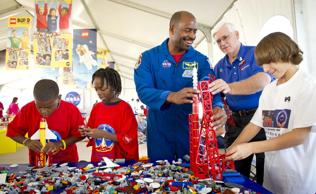 Associate Administrator for Education and Astronaut Leland Melvin, left, and  President of LEGO Education USA Stephan Turnipseed, right, help students during the “Build the Future” activity where students created their vision of the future in space with LEGO bricks and elements inside a tent that was set up on the launch viewing area at NASA's Kennedy Space Center in Cape Canaveral, Fla. on Monday, Nov. 1, 2010.  NASA and The LEGO Group signed a Space Act Agreement to spark children's interest in science, technology, engineering and math (STEM). Photo Credit: (NASA/Bill Ingalls)