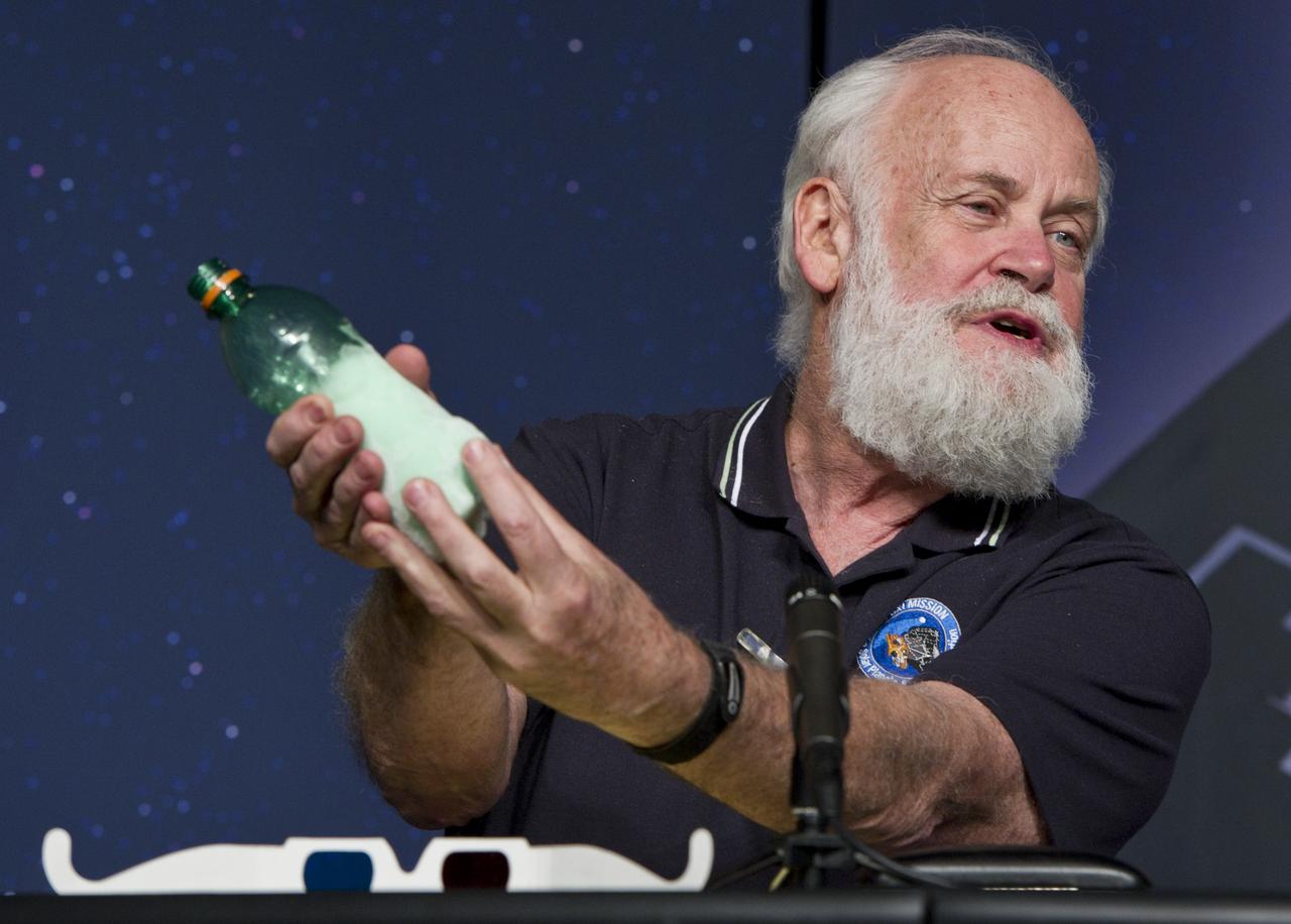 Michael A'Hearn, EPOXI Principal Investigator, University of Maryland, holds a plastic bottle containing ice to illustrate a point during a press conference, Thursday, Nov. 18, 2010, at NASA Headquarters in Washington. The press conference was held to discuss the Nov. 4 successful flyby of Comet Hartley 2 by NASA's EPOXI Mission Spacecraft. Images from the flyby provided scientists the most extensive observations of a comet in history. Photo Credit: (NASA/Paul E. Alers)