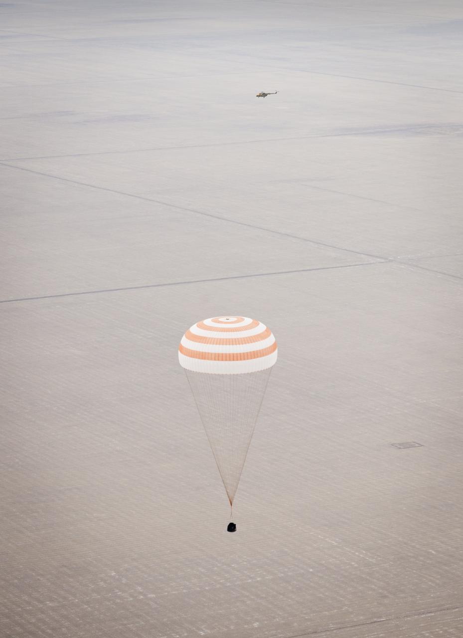 A Russian Search and Rescue hellicopter is seen in eth back ground as the Soyuz TMA-19 spacecraft descends with Expedition 25 Commander Doug Wheelock and Flight Engineers Shannon Walker and Fyodor Yurchikhin near the town of Arkalyk, Kazakhstan on Friday, Nov. 26, 2010.  Russian Cosmonaut Yurchikhin and NASA Astronauts Wheelock and Walker, are returning from nearly six months onboard the International Space Station where they served as members of the Expedition 24 and 25 crews. Photo Credit: (NASA/Bill Ingalls)