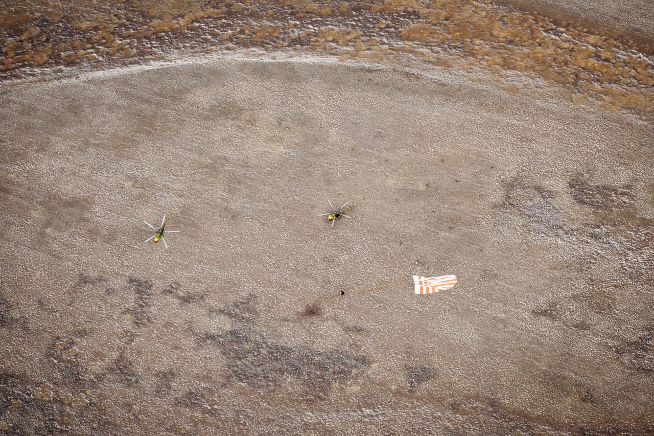 Two Russian Search and Rescue helicopters land near the Soyuz TMA-19 spacecraft shortly after touch down with Expedition 25 Commander Doug Wheelock and Flight Engineers Shannon Walker and Fyodor Yurchikhin near the town of Arkalyk, Kazakhstan on Friday, Nov. 26, 2010. Russian Cosmonaut Yurchikhin and NASA Astronauts Wheelock and Walker, are returning from nearly six months onboard the International Space Station where they served as members of the Expedition 24 and 25 crews. Photo Credit: (NASA/Bill Ingalls)