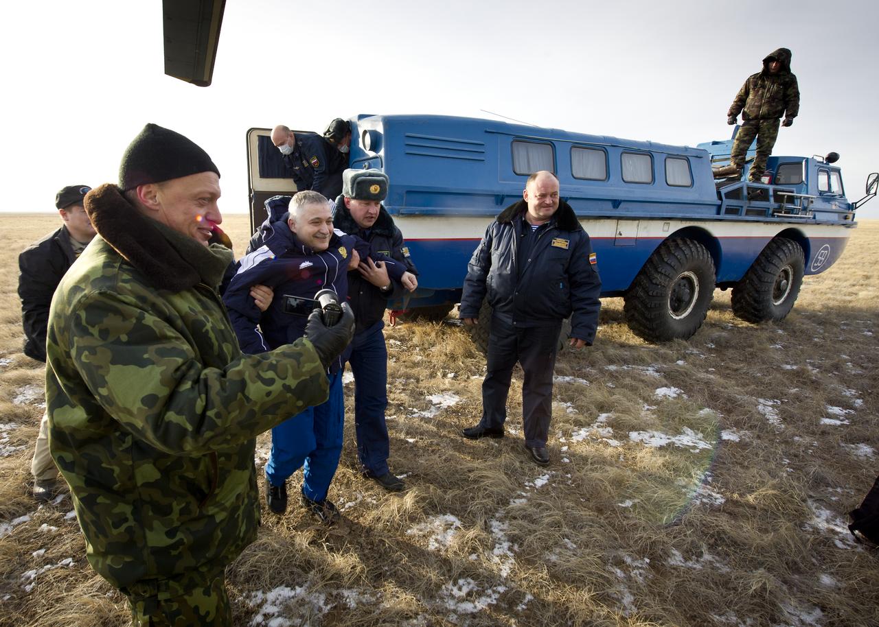 Expedition 25 Flight Engineer Fyodor Yurchikhin is helped from a Russian Search and Rescue all terrain vehicle to a helicopter shortly after Yurchikhin, Expedition 25 Commander Doug Wheelock and Flight Engineer Shannon Walker landed in the Soyuz TMA-19 spacecraft near Arkalyk, Kazakhstan on Friday, Nov. 26, 2010.  Russian Cosmonaut Yurchikhin and NASA Astronauts Wheelock and Walker, are returning from nearly six months onboard the International Space Station where they served as members of the Expedition 24 and 25 crews. Photo Credit: (NASA/Bill Ingalls)