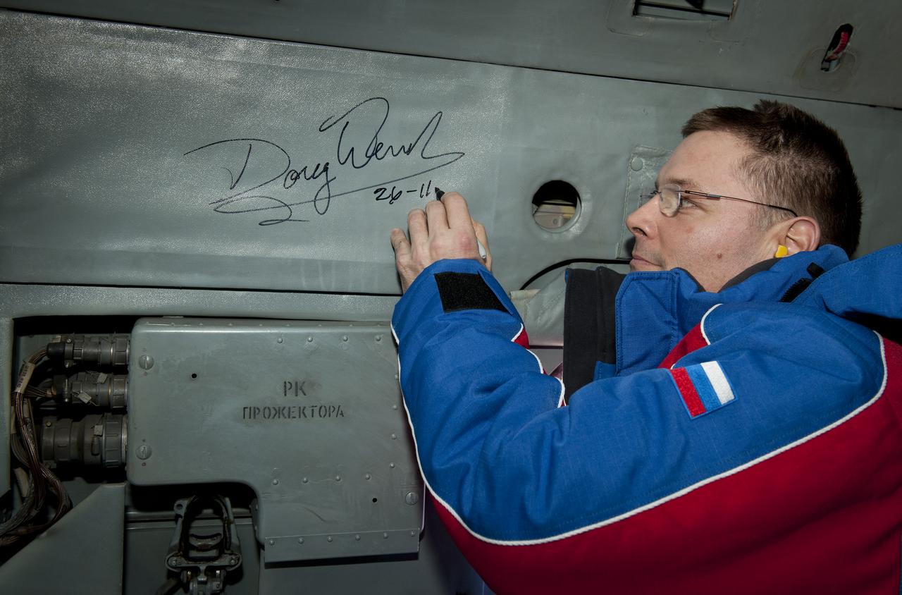 Expedition 25 Commander Doug Wheelock signs the inside of a Russian Search and Rescue helicopter shortly after Wheelock, Expedition 25 Flight Engineers Shannon Walker  and Fyodor Yurchikhin landed in the Soyuz TMA-19 spacecraft near Arkalyk, Kazakhstan on Friday, Nov. 26, 2010.  Russian Cosmonaut Yurchikhin and NASA Astronauts Wheelock and Walker, are returning from nearly six months onboard the International Space Station where they served as members of the Expedition 24 and 25 crews. Photo Credit: (NASA/Bill Ingalls)
