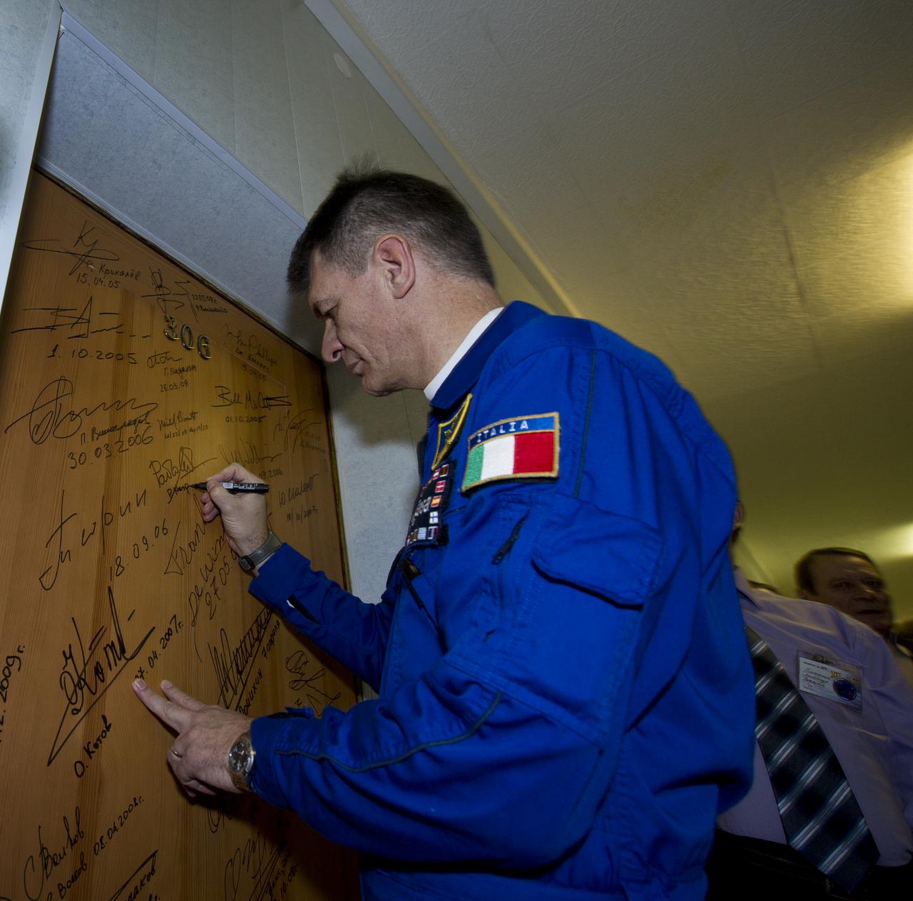 Expedition 26 European Space Agency astronaut and Flight Engineer Paolo Nespoli performs the traditional door signing Wednesday, Dec. 15, 2010 at the Cosmonaut Hotel in Baikonur, Kazakhstan. Nespoli was launched onboard the Soyuz rocket the following morning with Expedition 26 Soyuz Commander Dmitry Kondratyev and NASA Flight Engineer Catherine Coleman on a mission to the International Space Station (ISS). Photo Credit: (NASA/Carla Cioffi)