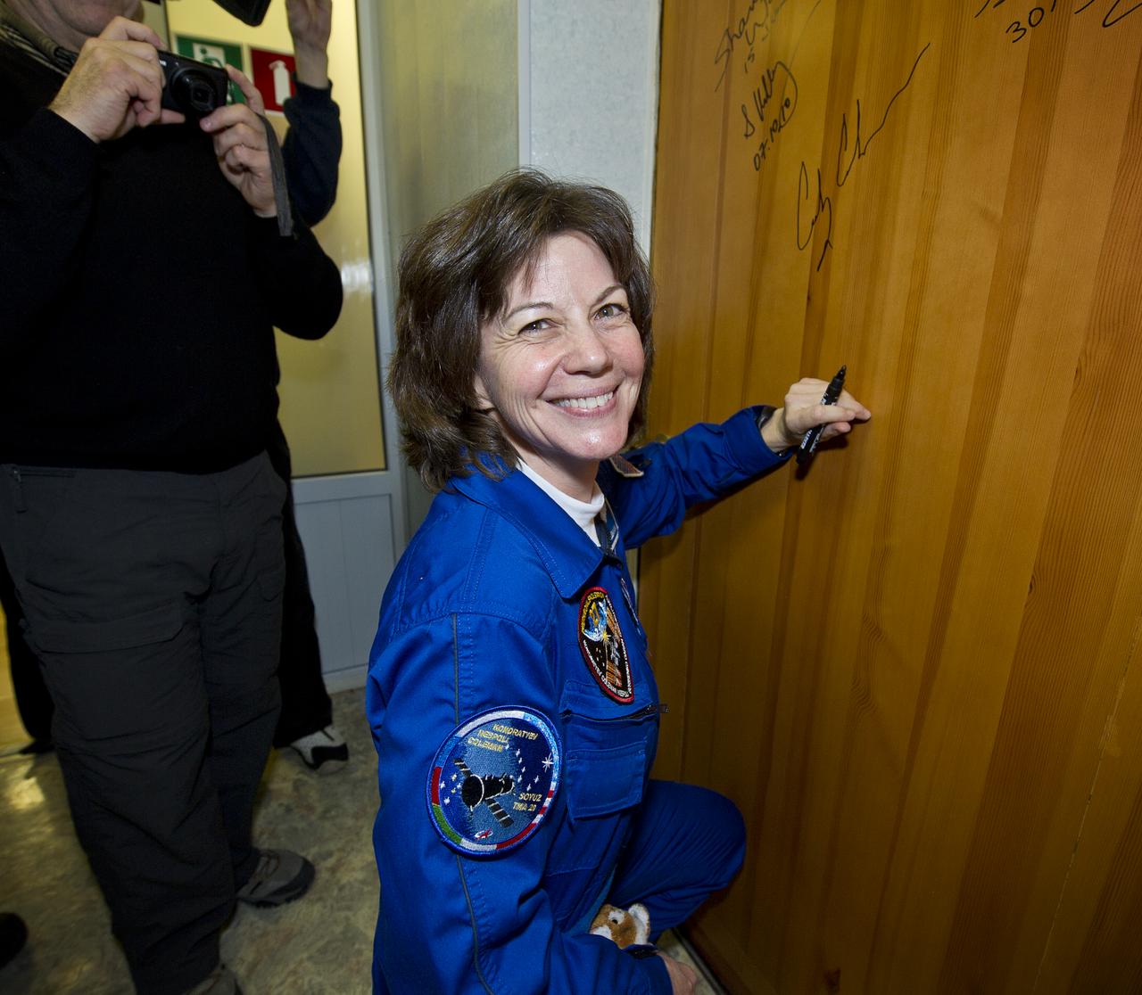Expedition 26 NASA Flight Engineer Catherine Coleman performs the traditional door signing Wednesday, Dec. 15, 2010 at the Cosmonaut Hotel in Baikonur, Kazakhstan. Coleman was launched onboard the Soyuz rocket the following morning with Expedition 26 Soyuz Commander Dmitry Kondratyev and ESA Flight Engineer Paolo Nespoli on a mission to the International Space Station (ISS). Photo Credit: (NASA/Carla Cioffi)