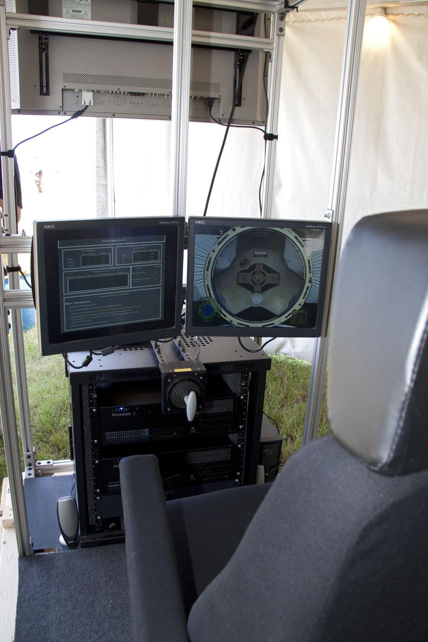 CAPE CANAVERAL, Fla. -- An interactive docking simulator developed by Lockheed Martin gave STS-134 launch guests at NASA's Kennedy Space Center in Florida the opportunity to fly a realistic docking maneuver with the International Space Station. The center screen provides the forward view to the docking target while the white T-shaped handle is used for translation corrections during the maneuver. The Sensor Test for Orion Relnav Risk Mitigation, or STORRM, flight test planned for space shuttle Endeavour's STS-134 mission will mature the sensor technologies to make these docking operations easier and safer for America's next-generation exploration spacecraft. STS-134 also will deliver the Express Logistics Carrier-3, Alpha Magnetic Spectrometer-2 (AMS), a high-pressure gas tank and additional spare parts for the Dextre robotic helper to the space station. Endeavour was scheduled to launch at 3:47 p.m. on April 29, but that attempt was scrubbed for at least 72 hours while engineers assess an issue associated with the shuttle's Auxiliary Power Unit 1. STS-134 will be the final spaceflight for Endeavour. For more information visit, www.nasa.gov_mission_pages_shuttle_shuttlemissions_sts134_index.html. Photo credit: NASA_Jack Pfaller