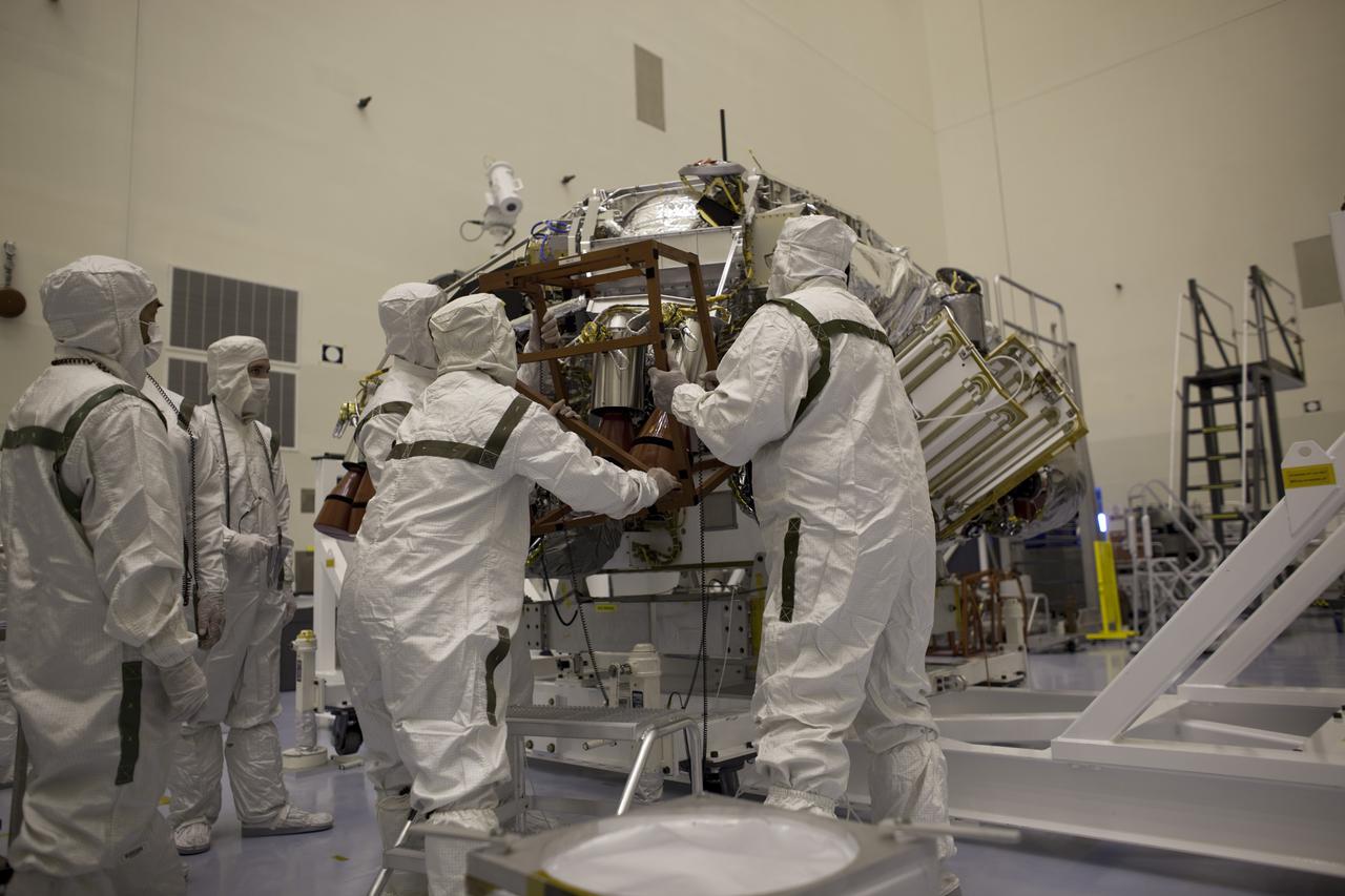 CAPE CANAVERAL, Fla. – In the Payload Hazardous Servicing Facility at NASA's Kennedy Space Center in Florida, technicians dressed in clean room attire, known as 'bunny' suits, prepare the Mars Science Laboratory (MSL) rover, Curiosity, for encapsulation inside a backshell by first removing the protective cage over the rockets on the descent stage. The spacecraft's backshell, a protective cover, carries the parachute and several components used during later stages of entry, descent and landing of the MSL's rover. A United Launch Alliance Atlas V-541 configuration will be used to loft MSL into space. MSL's components include a compact car-sized rover, Curiosity, which has 10 science instruments designed to search for evidence on whether Mars has had environments favorable to microbial life, including chemical ingredients for life. The unique rover will use a laser to look inside rocks and release its gasses so that the rover’s spectrometer can analyze and send the data back to Earth. MSL is scheduled to launch Nov. 25 with a window extending to Dec. 18 and arrival at Mars Aug. 2012. For more information, visit http:__www.nasa.gov_msl. Photo credit: NASA_Dimitri Gerondidakis