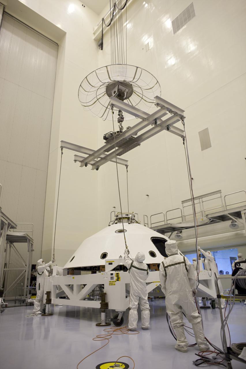 CAPE CANAVERAL, Fla. – In the Payload Hazardous Servicing Facility at NASA's Kennedy Space Center in Florida, technicians attach an overhead crane to the backshell for NASA's Mars Science Laboratory (MSL) rover, Curiosity. The backshell, a protective cover which carries the parachute and several components used during later stages of entry, descent and landing, will be encapsulated over the rover. A United Launch Alliance Atlas V-541 configuration will be used to loft MSL into space. MSL's components include a compact car-sized rover, Curiosity, which has 10 science instruments designed to search for evidence on whether Mars has had environments favorable to microbial life, including chemical ingredients for life. The unique rover will use a laser to look inside rocks and release its gasses so that the rover’s spectrometer can analyze and send the data back to Earth. MSL is scheduled to launch Nov. 25 with a window extending to Dec. 18 and arrival at Mars Aug. 2012. For more information, visit http:__www.nasa.gov_msl. Photo credit: NASA_Dimitri Gerondidakis