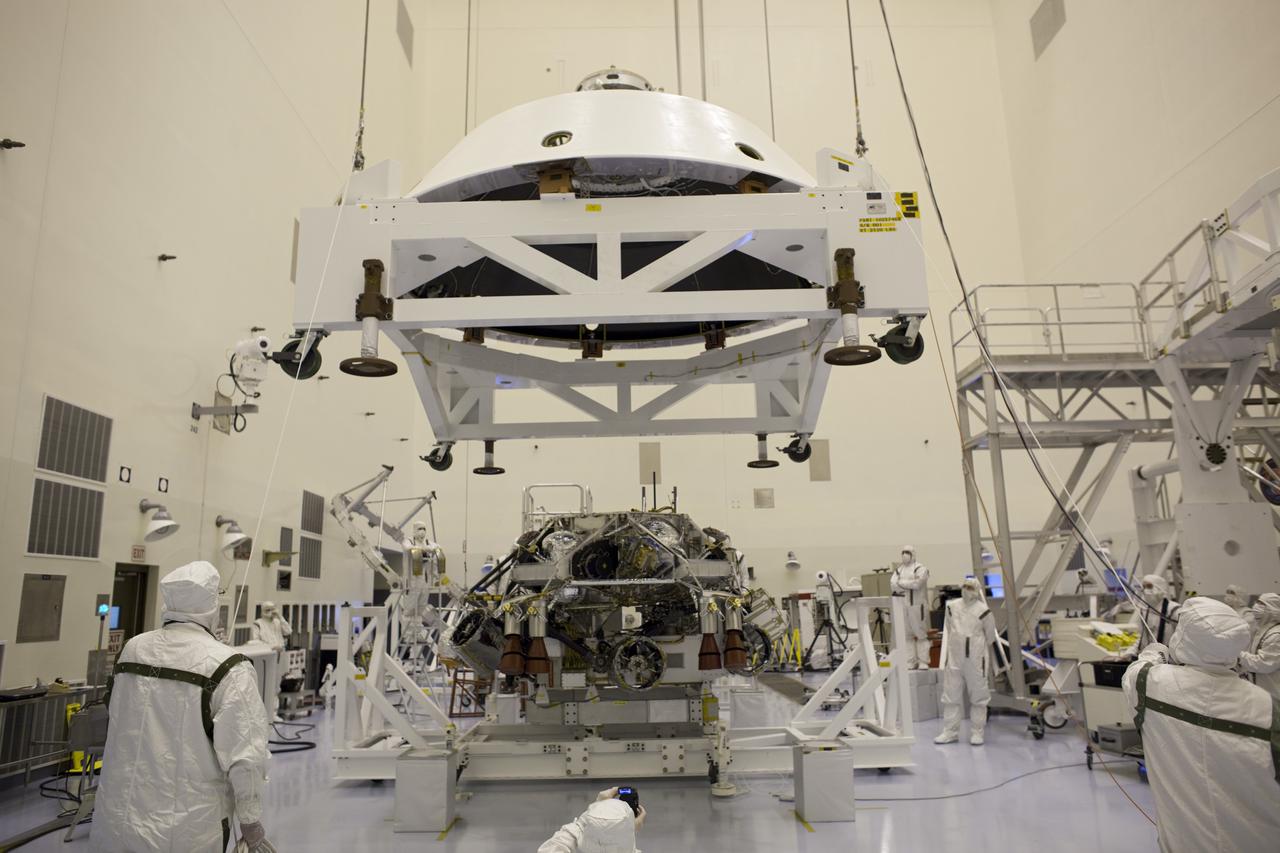 CAPE CANAVERAL, Fla. – In the Payload Hazardous Servicing Facility at NASA's Kennedy Space Center in Florida, technicians guide the backshell as it is lowered over NASA's Mars Science Laboratory (MSL) rover, Curiosity, for encapsulation. The backshell, a protective cover, carries the parachute and several components used during later stages of entry, descent and landing. A United Launch Alliance Atlas V-541 configuration will be used to loft MSL into space. MSL's components include a compact car-sized rover, Curiosity, which has 10 science instruments designed to search for evidence on whether Mars has had environments favorable to microbial life, including chemical ingredients for life. The unique rover will use a laser to look inside rocks and release its gasses so that the rover’s spectrometer can analyze and send the data back to Earth. MSL is scheduled to launch Nov. 25 with a window extending to Dec. 18 and arrival at Mars Aug. 2012. For more information, visit http:__www.nasa.gov_msl. Photo credit: NASA_Dimitri Gerondidakis