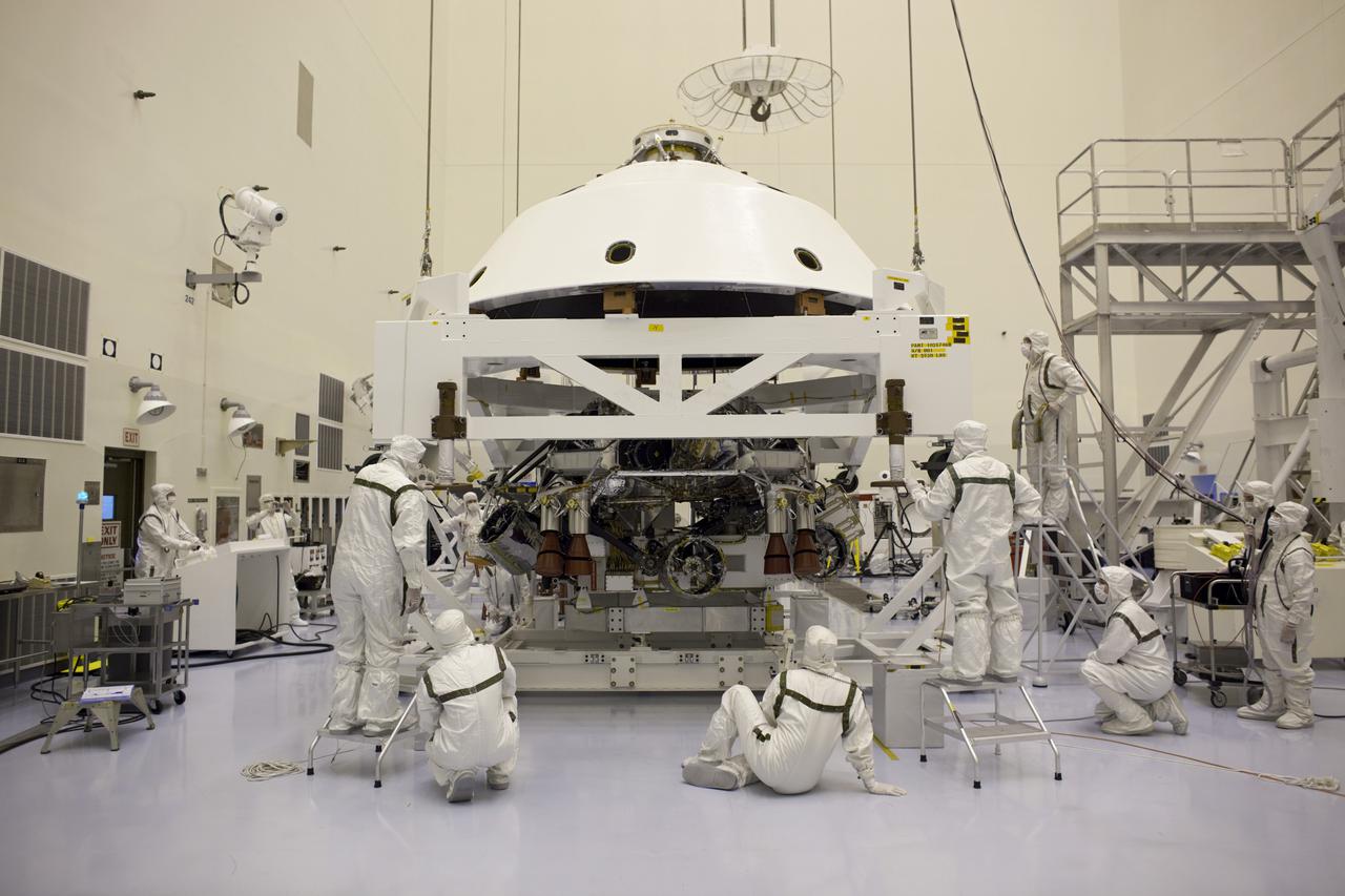 CAPE CANAVERAL, Fla. – In the Payload Hazardous Servicing Facility at NASA's Kennedy Space Center in Florida, technicians guide the backshell as it is lowered over NASA's Mars Science Laboratory (MSL) rover, Curiosity, for encapsulation. The backshell, a protective cover, carries the parachute and several components used during later stages of entry, descent and landing. A United Launch Alliance Atlas V-541 configuration will be used to loft MSL into space. MSL's components include a compact car-sized rover, Curiosity, which has 10 science instruments designed to search for evidence on whether Mars has had environments favorable to microbial life, including chemical ingredients for life. The unique rover will use a laser to look inside rocks and release its gasses so that the rover’s spectrometer can analyze and send the data back to Earth. MSL is scheduled to launch Nov. 25 with a window extending to Dec. 18 and arrival at Mars Aug. 2012. For more information, visit http:__www.nasa.gov_msl. Photo credit: NASA_Dimitri Gerondidakis