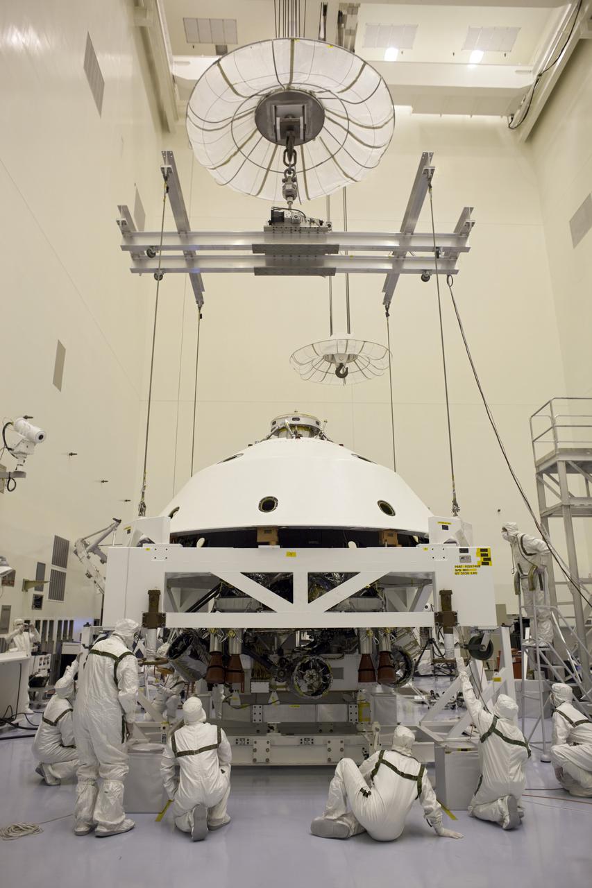 CAPE CANAVERAL, Fla. – In the Payload Hazardous Servicing Facility at NASA's Kennedy Space Center in Florida, technicians guide the backshell as it is lowered over NASA's Mars Science Laboratory (MSL) rover, Curiosity, for encapsulation. The backshell, a protective cover, carries the parachute and several components used during later stages of entry, descent and landing. A United Launch Alliance Atlas V-541 configuration will be used to loft MSL into space. MSL's components include a compact car-sized rover, Curiosity, which has 10 science instruments designed to search for evidence on whether Mars has had environments favorable to microbial life, including chemical ingredients for life. The unique rover will use a laser to look inside rocks and release its gasses so that the rover’s spectrometer can analyze and send the data back to Earth. MSL is scheduled to launch Nov. 25 with a window extending to Dec. 18 and arrival at Mars Aug. 2012. For more information, visit http:__www.nasa.gov_msl. Photo credit: NASA_Dimitri Gerondidakis