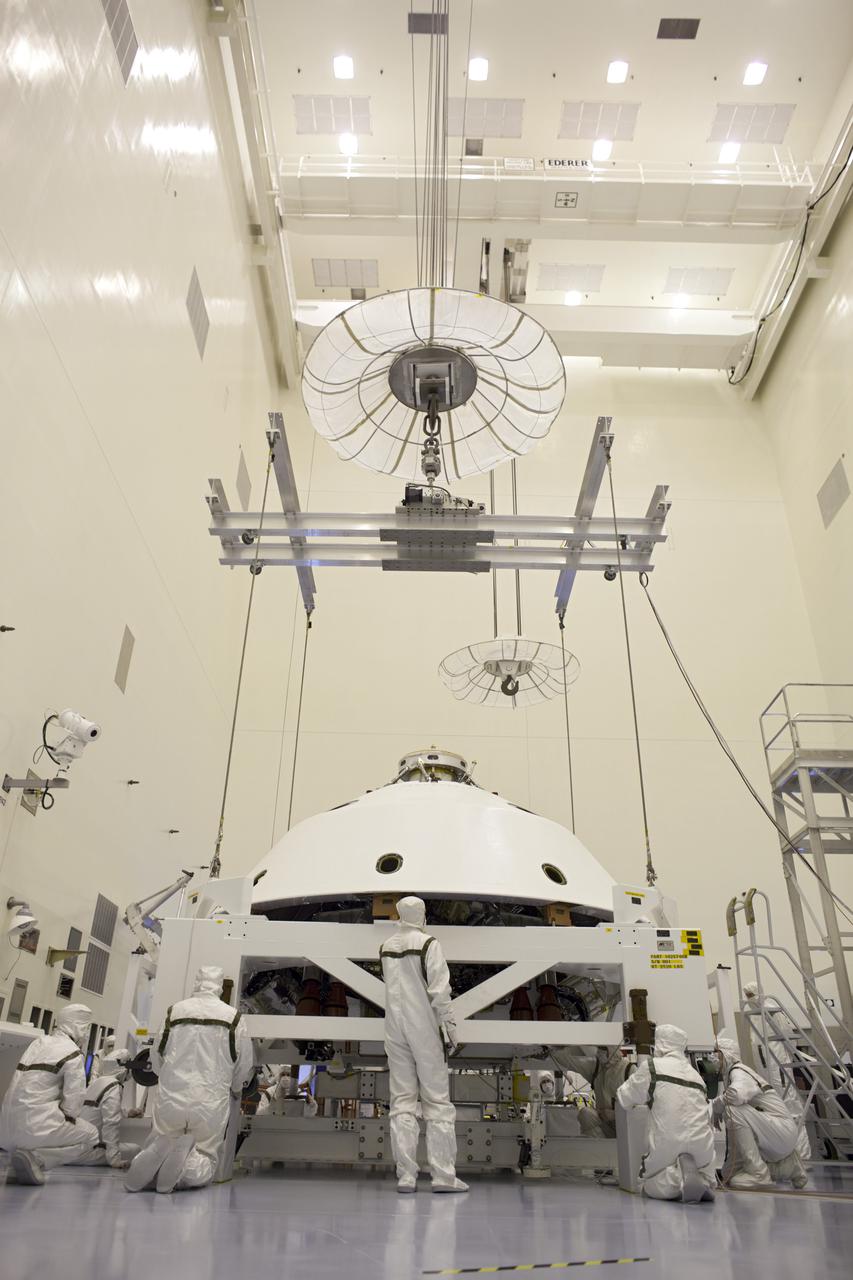 CAPE CANAVERAL, Fla. – In the Payload Hazardous Servicing Facility at NASA's Kennedy Space Center in Florida, technicians check the placement of the backshell over NASA's Mars Science Laboratory (MSL) rover, Curiosity. The backshell, a protective cover, carries the parachute and several components used during later stages of entry, descent and landing. A United Launch Alliance Atlas V-541 configuration will be used to loft MSL into space. MSL's components include a compact car-sized rover, Curiosity, which has 10 science instruments designed to search for evidence on whether Mars has had environments favorable to microbial life, including chemical ingredients for life. The unique rover will use a laser to look inside rocks and release its gasses so that the rover’s spectrometer can analyze and send the data back to Earth. MSL is scheduled to launch Nov. 25 with a window extending to Dec. 18 and arrival at Mars Aug. 2012. For more information, visit http:__www.nasa.gov_msl. Photo credit: NASA_Dimitri Gerondidakis