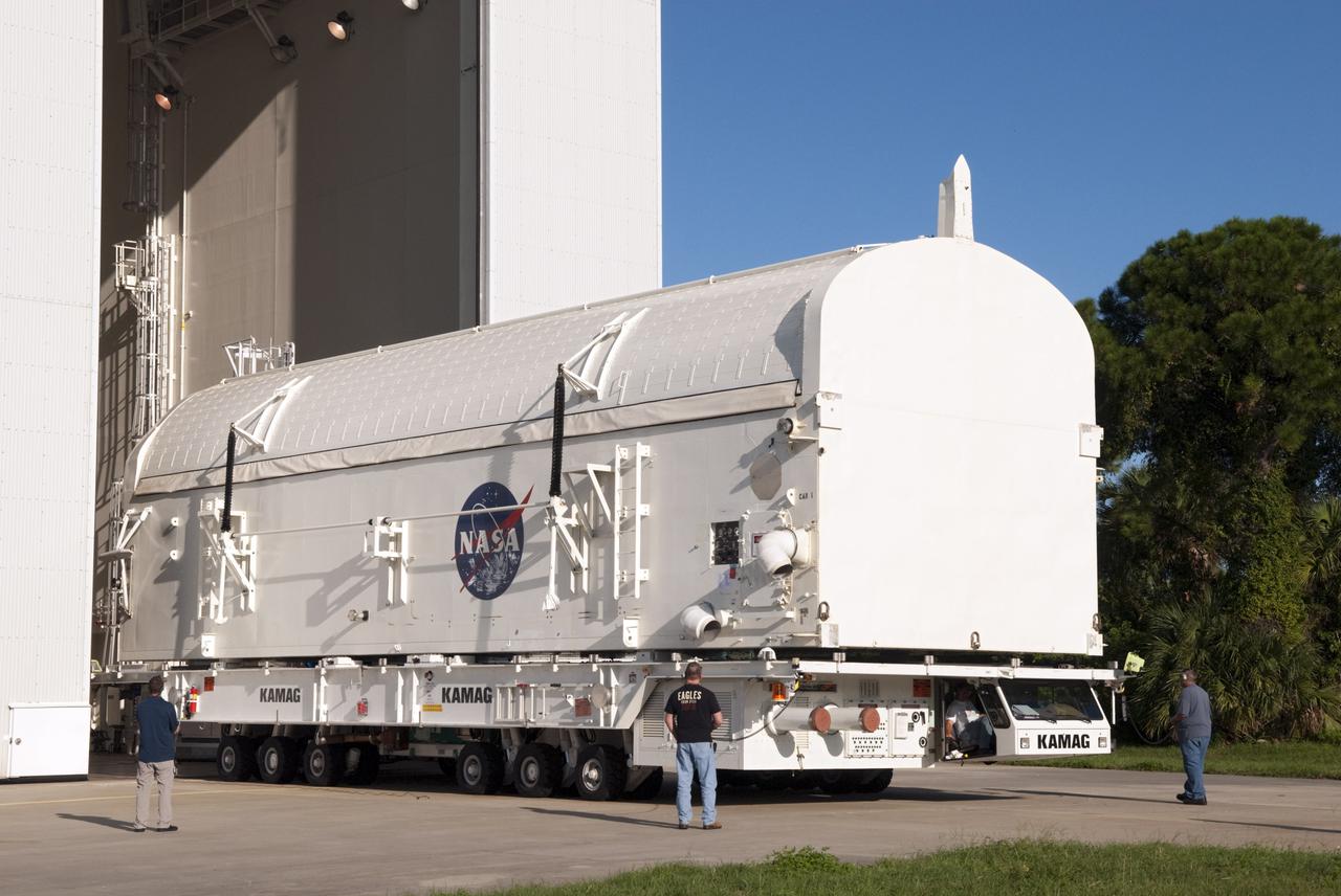 CAPE CANAVERAL, Fla. -- Employees monitor payload canister #1 as it rolls out of the high bay of the Canister Rotation Facility at NASA's Kennedy Space Center in Florida for its trip to the Reutilization, Recycling and Marketing Facility on Ransom Road.   The two payload canisters used to transport space shuttle payloads to the launch pad for installation in the shuttles' cargo bays are being decommissioned following the end of the Space Shuttle Program. Each canister weighs 110,000 pounds and is 65 feet long, 22 feet wide, and 18 feet, 7 inches high.  The canisters were prescreened through NASA Headquarters as possible artifacts, but their size makes them difficult to transport to locations off the center. Federal and state agencies now will be given the opportunity to screen the canisters for potential use before a final decision is made on their disposition.  For more information, visit http:__www.nasa.gov_centers_kennedy_pdf_167403main_CRF-06.pdf. Photo credit: NASA_Jim Grossmann