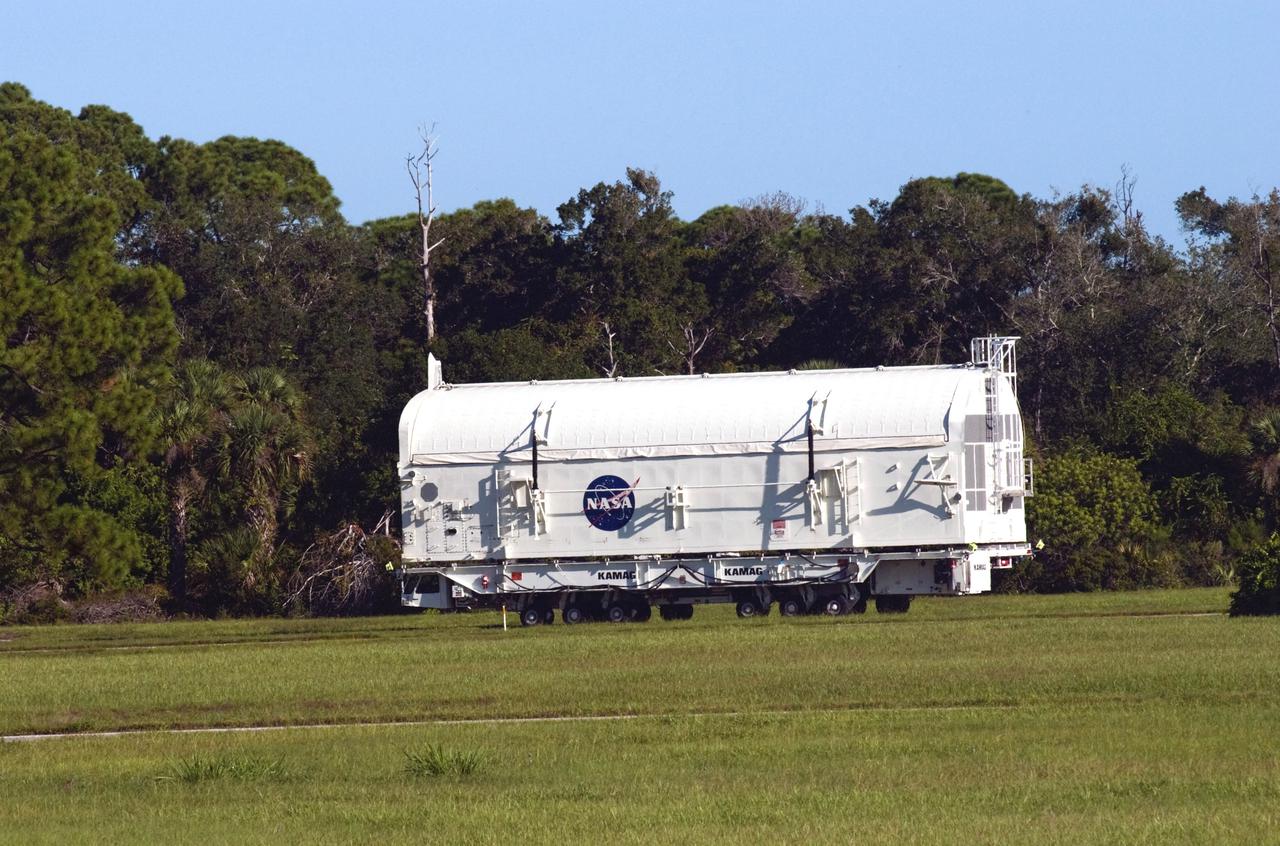 CAPE CANAVERAL, Fla. -- At NASA's Kennedy Space Center in Florida, payload canister #1 travels at a slow, steady 5 mph from the Canister Rotation Facility to the Reutilization, Recycling and Marketing Facility on Ransom Road.  The two payload canisters used to transport space shuttle payloads to the launch pad for installation in the shuttles' cargo bays are being decommissioned following the end of the Space Shuttle Program. Each canister weighs 110,000 pounds and is 65 feet long, 22 feet wide, and 18 feet, 7 inches high.  The canisters were prescreened through NASA Headquarters as possible artifacts, but their size makes them difficult to transport to locations off the center. Federal and state agencies now will be given the opportunity to screen the canisters for potential use before a final decision is made on their disposition.  For more information, visit http:__www.nasa.gov_centers_kennedy_pdf_167403main_CRF-06.pdf. Photo credit: NASA_Jim Grossmann