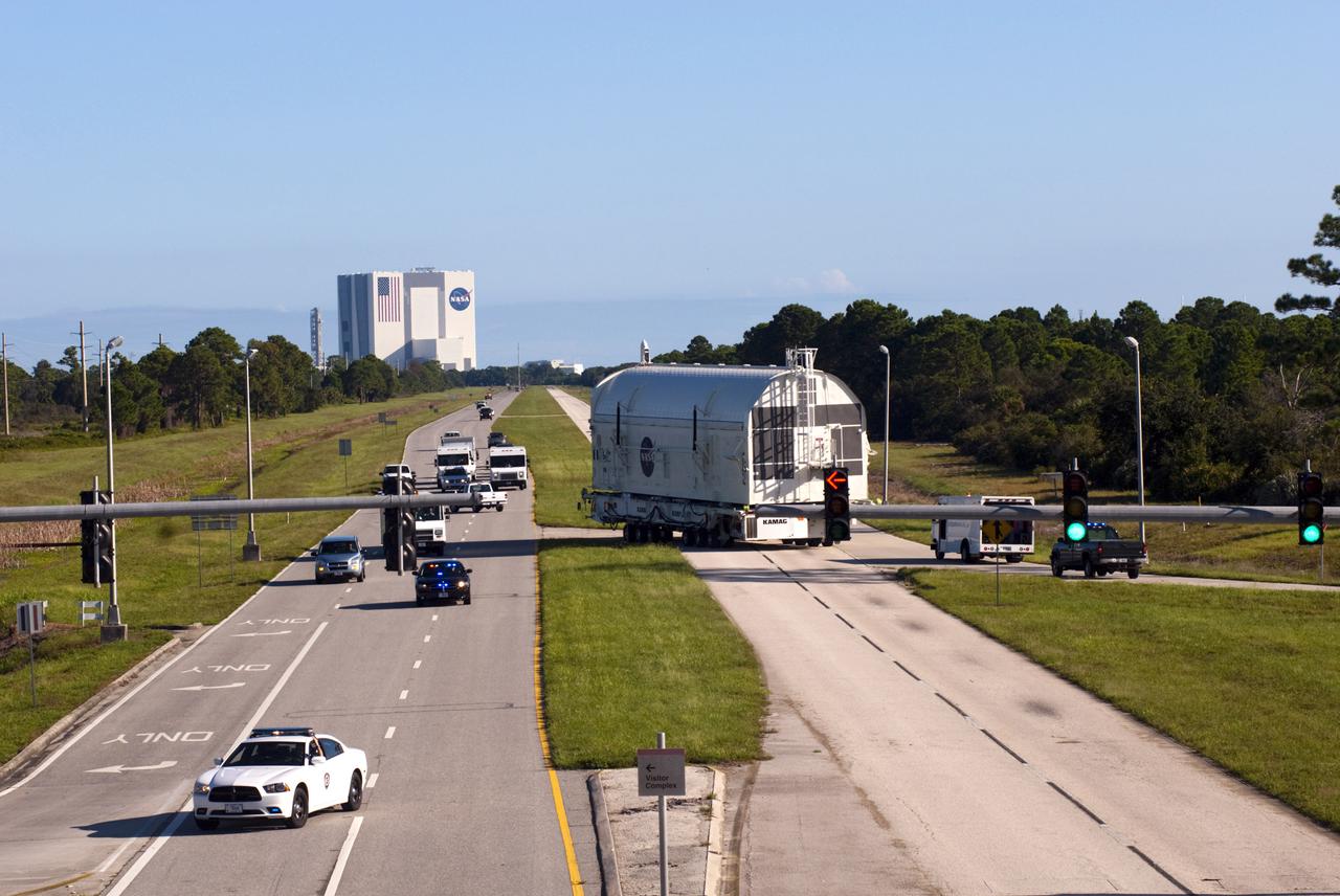 CAPE CANAVERAL, Fla. -- At NASA's Kennedy Space Center in Florida, payload canister #1, traveling from the Canister Rotation Facility in the center's Industrial Area to the Reutilization, Recycling and Marketing Facility on Ransom Road, is forced to take a circuitous route toward the Vehicle Assembly Building, in the background, to avoid obstacles along the way.  The two payload canisters used to transport space shuttle payloads to the launch pad for installation in the shuttles' cargo bays are being decommissioned following the end of the Space Shuttle Program. Each canister weighs 110,000 pounds and is 65 feet long, 22 feet wide, and 18 feet, 7 inches high.  The canisters were prescreened through NASA Headquarters as possible artifacts, but their size makes them difficult to transport to locations off the center. Federal and state agencies now will be given the opportunity to screen the canisters for potential use before a final decision is made on their disposition.  For more information, visit http:__www.nasa.gov_centers_kennedy_pdf_167403main_CRF-06.pdf. Photo credit: NASA_Jim Grossmann