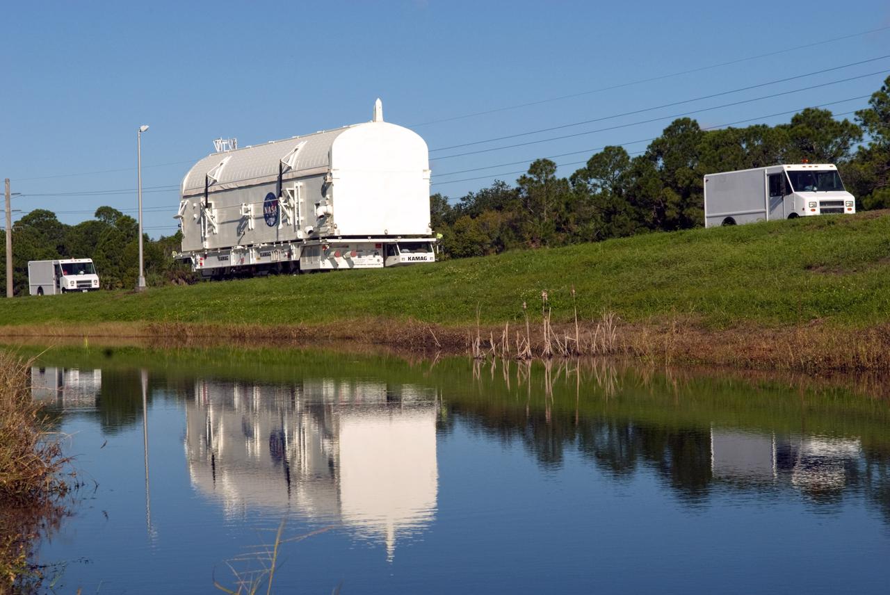 CAPE CANAVERAL, Fla. -- At NASA's Kennedy Space Center in Florida, payload canister #1 is reflected in the water standing beside the roadway leading from the Canister Rotation Facility to the Reutilization, Recycling and Marketing Facility on Ransom Road.   The two payload canisters used to transport space shuttle payloads to the launch pad for installation in the shuttles' cargo bays are being decommissioned following the end of the Space Shuttle Program. Each canister weighs 110,000 pounds and is 65 feet long, 22 feet wide, and 18 feet, 7 inches high.  The canisters were prescreened through NASA Headquarters as possible artifacts, but their size makes them difficult to transport to locations off the center. Federal and state agencies now will be given the opportunity to screen the canisters for potential use before a final decision is made on their disposition.  For more information, visit http:__www.nasa.gov_centers_kennedy_pdf_167403main_CRF-06.pdf. Photo credit: NASA_Jim Grossmann
