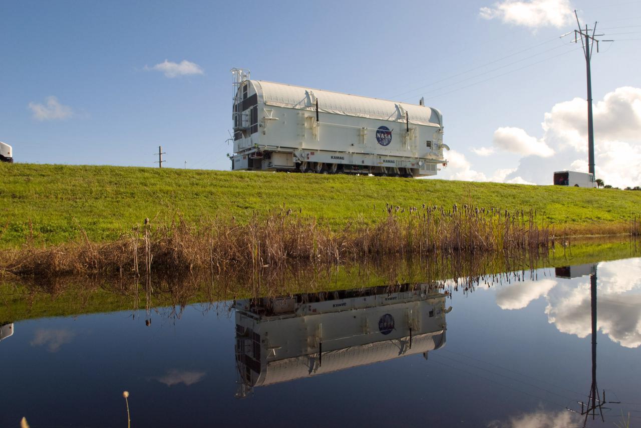 CAPE CANAVERAL, Fla. -- At NASA's Kennedy Space Center in Florida, payload canister #1 is reflected in the water standing beside the roadway leading from the Canister Rotation Facility to the Reutilization, Recycling and Marketing Facility on Ransom Road.  The two payload canisters used to transport space shuttle payloads to the launch pad for installation in the shuttles' cargo bays are being decommissioned following the end of the Space Shuttle Program. Each canister weighs 110,000 pounds and is 65 feet long, 22 feet wide, and 18 feet, 7 inches high.  The canisters were prescreened through NASA Headquarters as possible artifacts, but their size makes them difficult to transport to locations off the center. Federal and state agencies now will be given the opportunity to screen the canisters for potential use before a final decision is made on their disposition.  For more information, visit http:__www.nasa.gov_centers_kennedy_pdf_167403main_CRF-06.pdf. Photo credit: NASA_Jim Grossmann