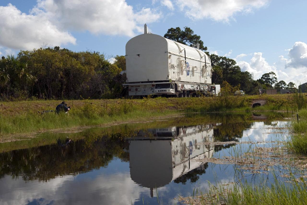 CAPE CANAVERAL, Fla. -- At NASA's Kennedy Space Center in Florida, payload canister #1 is reflected in the water standing beside the roadway leading to the Reutilization, Recycling and Marketing Facility on Ransom Road.   The two payload canisters used to transport space shuttle payloads to the launch pad for installation in the shuttles' cargo bays are being decommissioned following the end of the Space Shuttle Program. Each canister weighs 110,000 pounds and is 65 feet long, 22 feet wide, and 18 feet, 7 inches high.  The canisters were prescreened through NASA Headquarters as possible artifacts, but their size makes them difficult to transport to locations off the center. Federal and state agencies now will be given the opportunity to screen the canisters for potential use before a final decision is made on their disposition.  For more information, visit http:__www.nasa.gov_centers_kennedy_pdf_167403main_CRF-06.pdf. Photo credit: NASA_Jim Grossmann