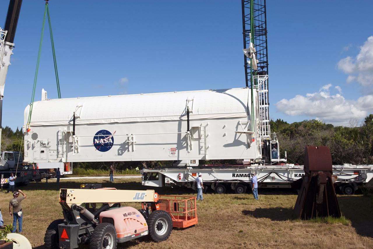 CAPE CANAVERAL, Fla. -- Cranes lift payload canister #1 from the transporter that delivered it to the Reutilization, Recycling and Marketing Facility on Ransom Road at NASA's Kennedy Space Center in Florida.   The two payload canisters used to transport space shuttle payloads to the launch pad for installation in the shuttles' cargo bays are being decommissioned following the end of the Space Shuttle Program. Each canister weighs 110,000 pounds and is 65 feet long, 22 feet wide, and 18 feet, 7 inches high.  The canisters were prescreened through NASA Headquarters as possible artifacts, but their size makes them difficult to transport to locations off the center. Federal and state agencies now will be given the opportunity to screen the canisters for potential use before a final decision is made on their disposition.  For more information, visit http:__www.nasa.gov_centers_kennedy_pdf_167403main_CRF-06.pdf. Photo credit: NASA_Jim Grossmann