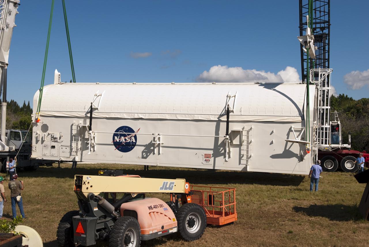 CAPE CANAVERAL, Fla. -- Cranes lower payload canister #1 to the ground outside the Reutilization, Recycling and Marketing Facility on Ransom Road at NASA's Kennedy Space Center in Florida.  The two payload canisters used to transport space shuttle payloads to the launch pad for installation in the shuttles' cargo bays are being decommissioned following the end of the Space Shuttle Program. Each canister weighs 110,000 pounds and is 65 feet long, 22 feet wide, and 18 feet, 7 inches high.  The canisters were prescreened through NASA Headquarters as possible artifacts, but their size makes them difficult to transport to locations off the center. Federal and state agencies now will be given the opportunity to screen the canisters for potential use before a final decision is made on their disposition.  For more information, visit http:__www.nasa.gov_centers_kennedy_pdf_167403main_CRF-06.pdf. Photo credit: NASA_Jim Grossmann