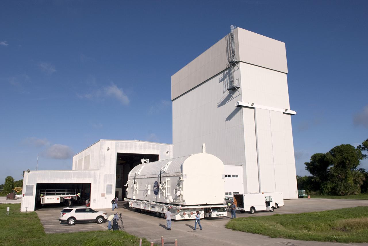 CAPE CANAVERAL, Fla. -- Employees monitor payload canister #2 as it rolls out of the high bay of the Canister Rotation Facility at NASA's Kennedy Space Center in Florida for its trip to the Reutilization, Recycling and Marketing Facility on Ransom Road.   The two payload canisters used to transport space shuttle payloads to the launch pad for installation in the shuttles' cargo bays are being decommissioned following the end of the Space Shuttle Program. Each canister weighs 110,000 pounds and is 65 feet long, 22 feet wide, and 18 feet, 7 inches high.  The canisters were prescreened through NASA Headquarters as possible artifacts, but their size makes them difficult to transport to locations off the center. Federal and state agencies now will be given the opportunity to screen the canisters for potential use before a final decision is made on their disposition.  For more information, visit http:__www.nasa.gov_centers_kennedy_pdf_167403main_CRF-06.pdf. Photo credit: NASA_Jim Grossmann