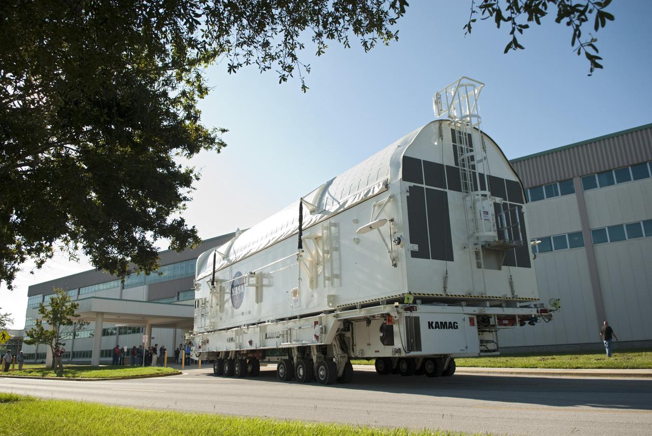 CAPE CANAVERAL, Fla. -- Payload canister #2 approaches the Space Station Processing Facility for a group employee photo opportunity.  The canister is on its way from the Canister Rotation Facility at NASA's Kennedy Space Center in Florida to the Reutilization, Recycling and Marketing Facility on Ransom Road.   The two payload canisters used to transport space shuttle payloads to the launch pad for installation in the shuttles' cargo bays are being decommissioned following the end of the Space Shuttle Program. Each canister weighs 110,000 pounds and is 65 feet long, 22 feet wide, and 18 feet, 7 inches high.  The canisters were prescreened through NASA Headquarters as possible artifacts, but their size makes them difficult to transport to locations off the center. Federal and state agencies now will be given the opportunity to screen the canisters for potential use before a final decision is made on their disposition.  For more information, visit http:__www.nasa.gov_centers_kennedy_pdf_167403main_CRF-06.pdf. Photo credit: NASA_Jim Grossmann