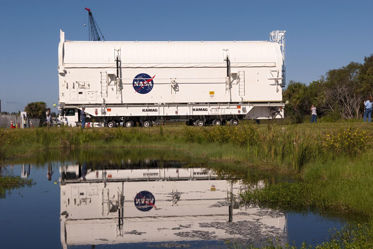 CAPE CANAVERAL, Fla. -- At NASA's Kennedy Space Center in Florida, payload canister #2 is reflected in the water standing beside the roadway leading to the Reutilization, Recycling and Marketing Facility on Ransom Road.  The two payload canisters used to transport space shuttle payloads to the launch pad for installation in the shuttles' cargo bays are being decommissioned following the end of the Space Shuttle Program. Each canister weighs 110,000 pounds and is 65 feet long, 22 feet wide, and 18 feet, 7 inches high.  The canisters were prescreened through NASA Headquarters as possible artifacts, but their size makes them difficult to transport to locations off the center. Federal and state agencies now will be given the opportunity to screen the canisters for potential use before a final decision is made on their disposition.  For more information, visit http:__www.nasa.gov_centers_kennedy_pdf_167403main_CRF-06.pdf. Photo credit: NASA_Jim Grossmann
