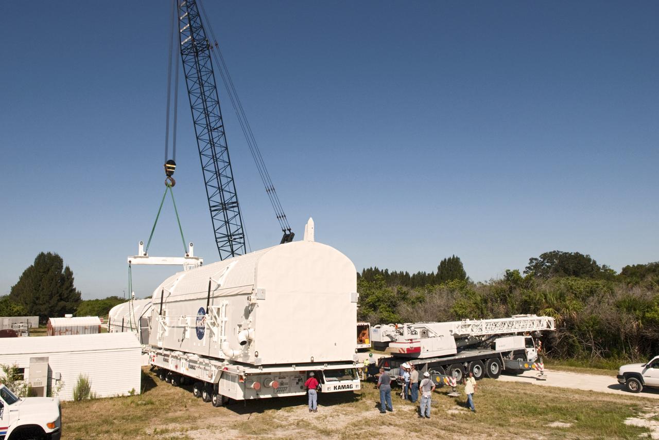 CAPE CANAVERAL, Fla. -- Preparations are under way to lift payload canister #2 from the transporter that delivered it to the Reutilization, Recycling and Marketing Facility on Ransom Road at NASA's Kennedy Space Center in Florida.   The two payload canisters used to transport space shuttle payloads to the launch pad for installation in the shuttles' cargo bays are being decommissioned following the end of the Space Shuttle Program. Each canister weighs 110,000 pounds and is 65 feet long, 22 feet wide, and 18 feet, 7 inches high.  The canisters were prescreened through NASA Headquarters as possible artifacts, but their size makes them difficult to transport to locations off the center. Federal and state agencies now will be given the opportunity to screen the canisters for potential use before a final decision is made on their disposition.  For more information, visit http:__www.nasa.gov_centers_kennedy_pdf_167403main_CRF-06.pdf. Photo credit: NASA_Jim Grossmann
