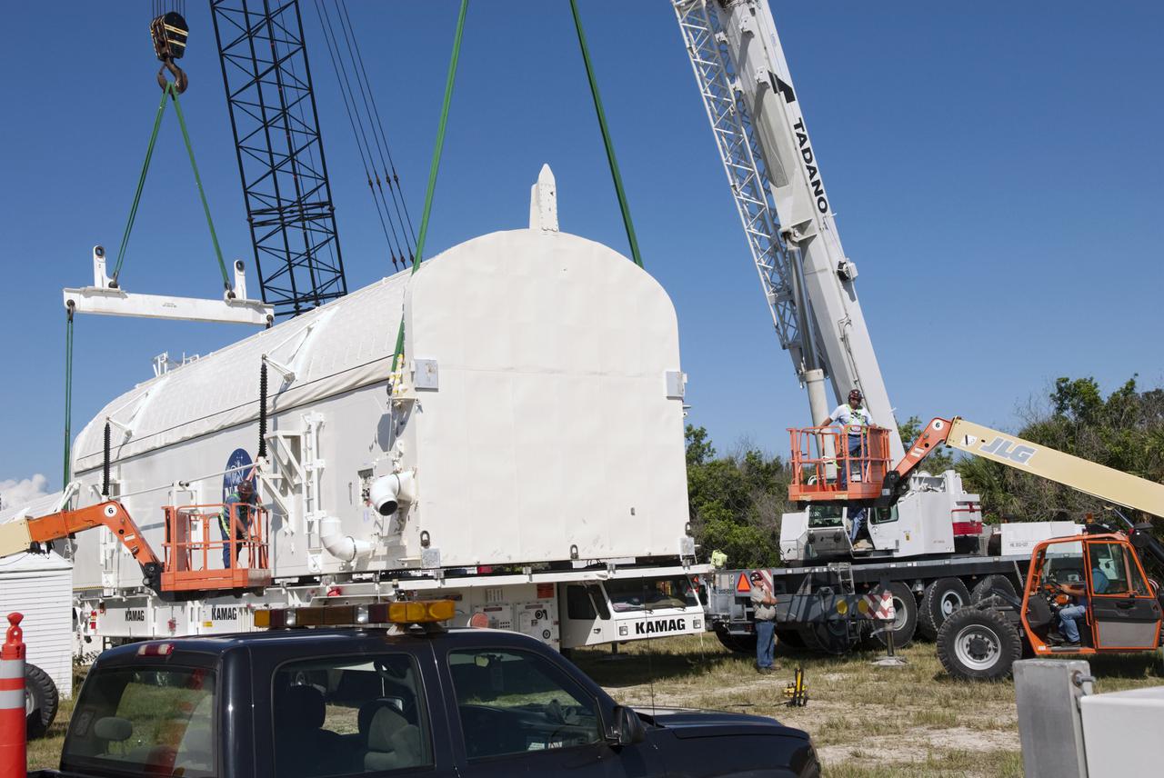 CAPE CANAVERAL, Fla. -- Cranes are attached to payload canister #2 to lift it from the transporter that delivered it to the Reutilization, Recycling and Marketing Facility on Ransom Road at NASA's Kennedy Space Center in Florida.  The two payload canisters used to transport space shuttle payloads to the launch pad for installation in the shuttles' cargo bays are being decommissioned following the end of the Space Shuttle Program. Each canister weighs 110,000 pounds and is 65 feet long, 22 feet wide, and 18 feet, 7 inches high.  The canisters were prescreened through NASA Headquarters as possible artifacts, but their size makes them difficult to transport to locations off the center. Federal and state agencies now will be given the opportunity to screen the canisters for potential use before a final decision is made on their disposition.  For more information, visit http:__www.nasa.gov_centers_kennedy_pdf_167403main_CRF-06.pdf. Photo credit: NASA_Jim Grossmann